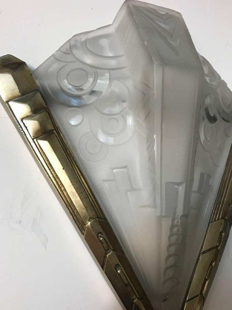 Stunning pair of French Art Deco geometric sconces signed by Muller Freres Luneville. Having clear frosted glass with over flowing geometric motif details. Each shade is signed Muller Frères. Supported by matching layered multi-tiered, geometric