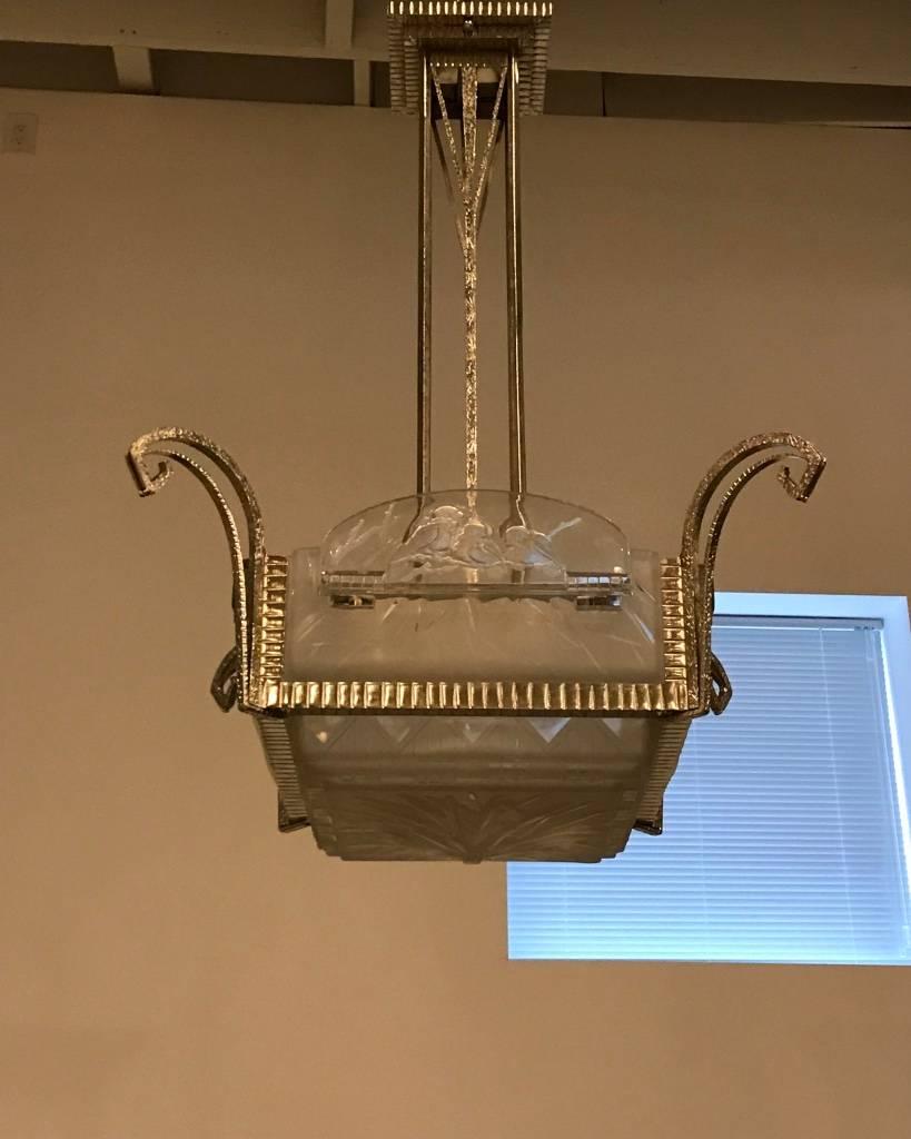 Stunning French Art Deco geometric chandelier signed by Muller Frères Luneville. Having clear frosted glass with over flowing geometric motif details. The four side panels have geometric with beautiful bird motif. The center panel having geometric