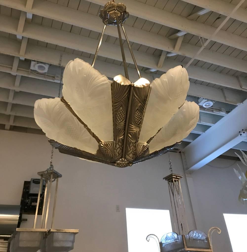 French Art Deco pine cone chandelier. Having six frosted glass panels with pine cone and Deco motif. Mounted on a matching polished nickel bronze geometric pine cone design frame. 
Height can be adjusted upon request.