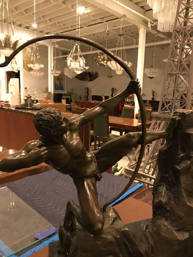 Beautiful Art Deco bronze of nude man with bow standing on rock with marble base.
