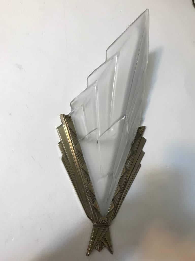 Beautiful pair of French Art Deco wall sconces signed by the French artist “Degue” in clear frosted glass shades with geometric motif. Each shade is marked Degue, held by geometric Nickelled frames. Replating upon request.