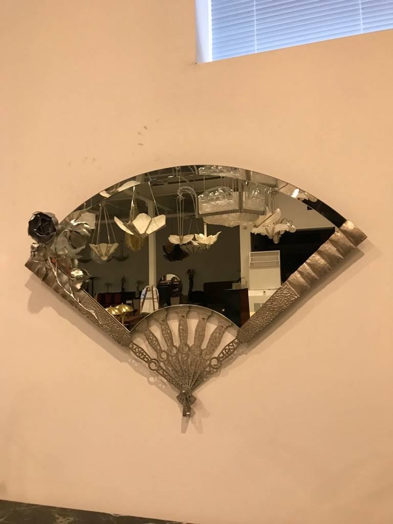 Stunning French Art Deco Mirror. Having hand-cut metal details in the center of the frame. With beautiful detail of a flower on the left side of the mirror. The frame has been plated in polished nickel.