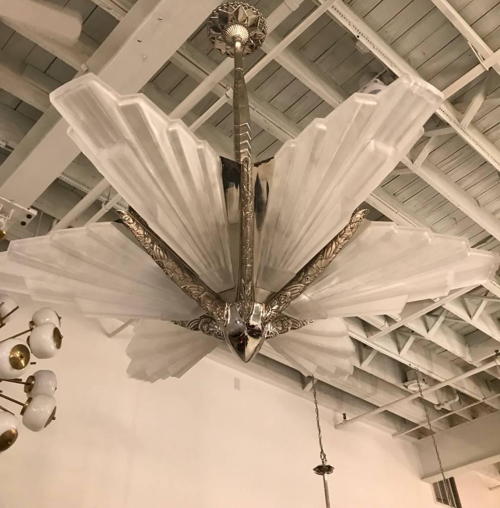 Stunning French Art Deco chandelier by the French artist "Sabino". With six beautiful clear frosted molded glass shades having skyscraper geometric motif. Polished details mounted on a silvered bronze frame with a floral design. Height can