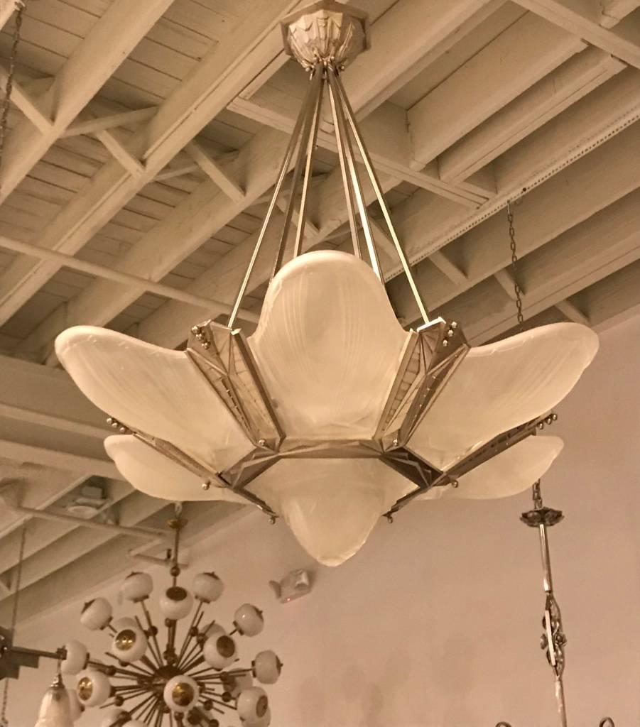 Gorgeous French Art Deco chandelier signed by Des Hanots. With six outer clear frosted glass panels and beautiful center bowl having geometric motif. Polished details on a silvered nickel frame with a geometric design continuing to the ceiling