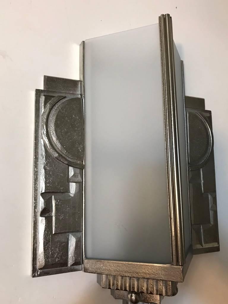 Gorgeous pair of French Art Deco geometric cubist wall sconce. With four frosted glass panels. Having intricate geometric motif details throughout the polished nickel design frame. Has been rewired for american use. Each sconces takes two 60 watt
