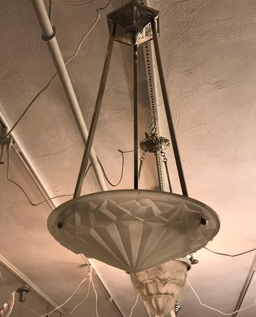 French Art Deco chandelier by famous artist Degue. Having clear frosted glass with over flowing geometric motif details. Supported by matching polished nickel geometric ceiling plate.