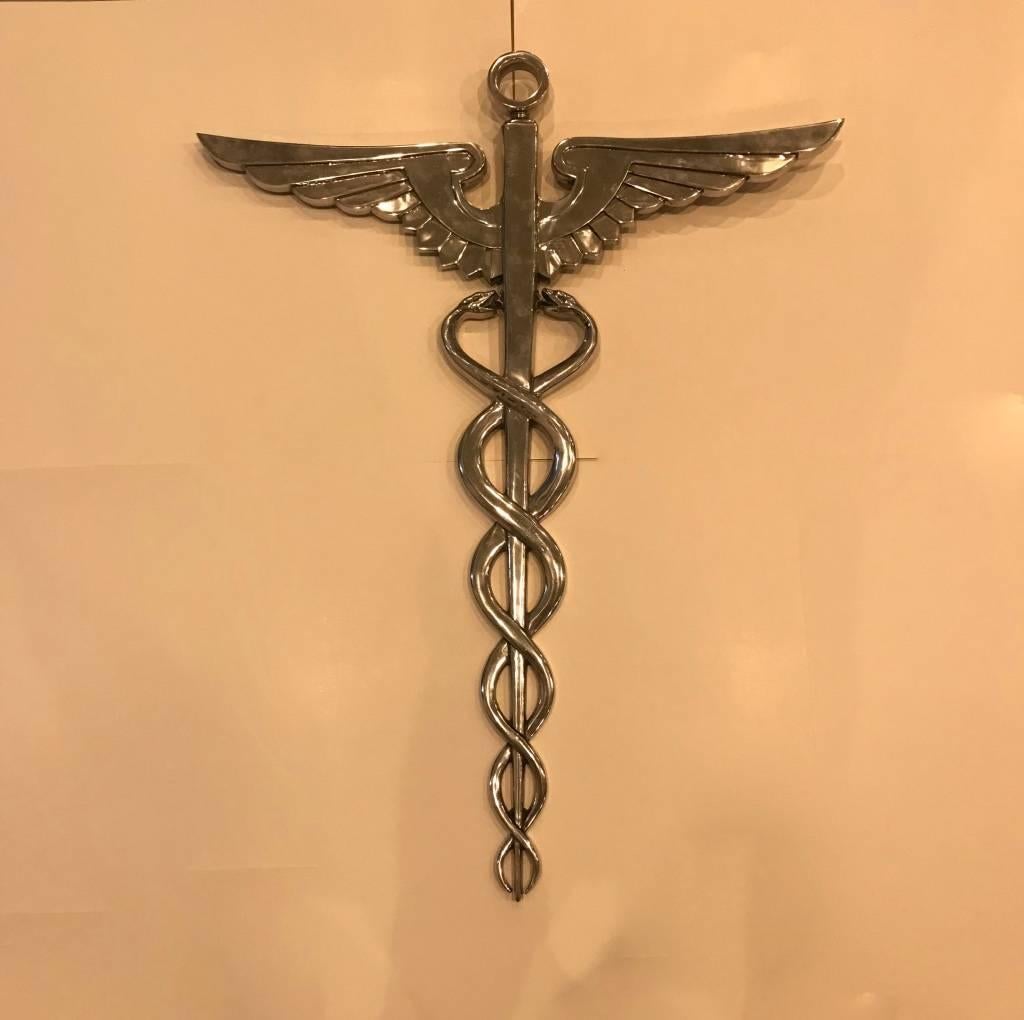 Stunning Mid-Century Modern chrome medical plaque caduceus. Features two snakes winding around a winged staff.