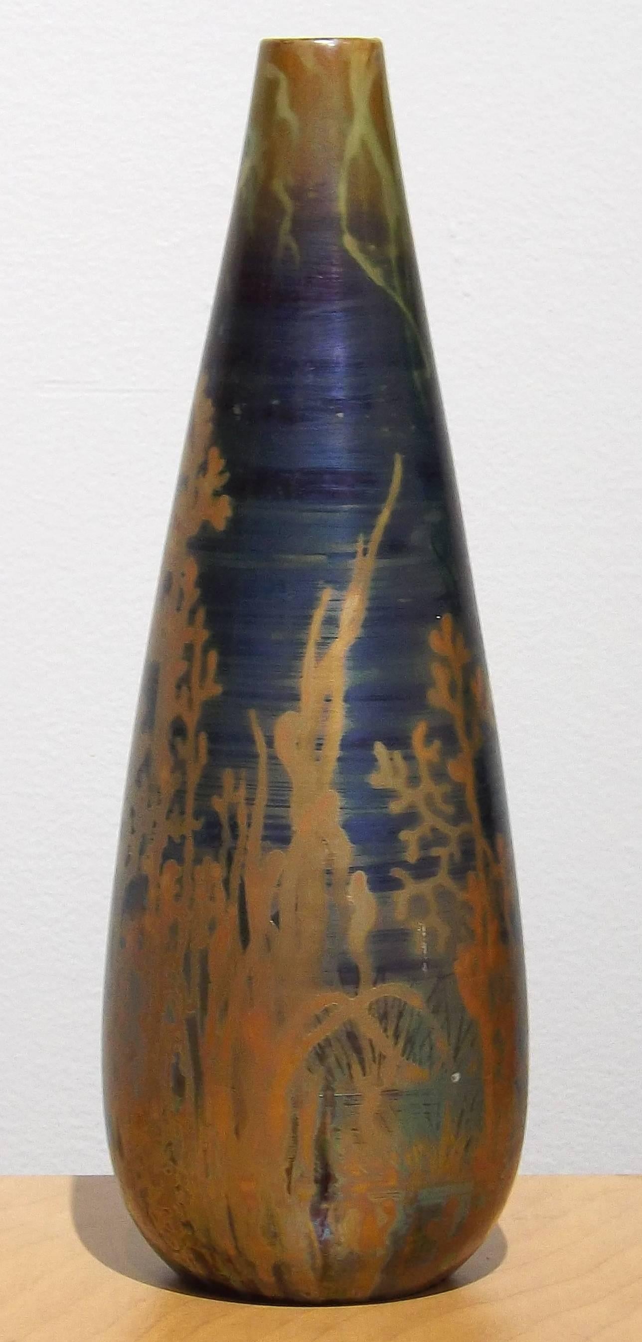 A wonderful Art Nouveau vase made by Clément Massier (1844-1917) with an underwater scene of water plants rising up to meet the roots of water lilies, executed in a magnificent blue and gold luster. Painted and impressed signature of the