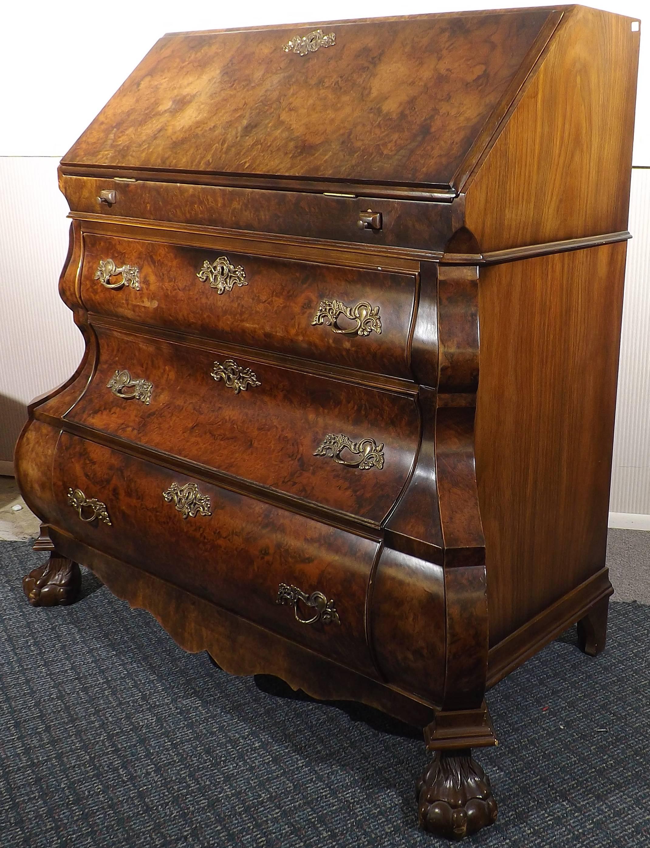 A magnificent Dutch bombe drop-front desk done in walnut burl on claw and ball feet. Beautiful marquetry work and with two 'secret' compartments disguised as books. Two pull-out arms support the fold down writing surface, which can be closed and