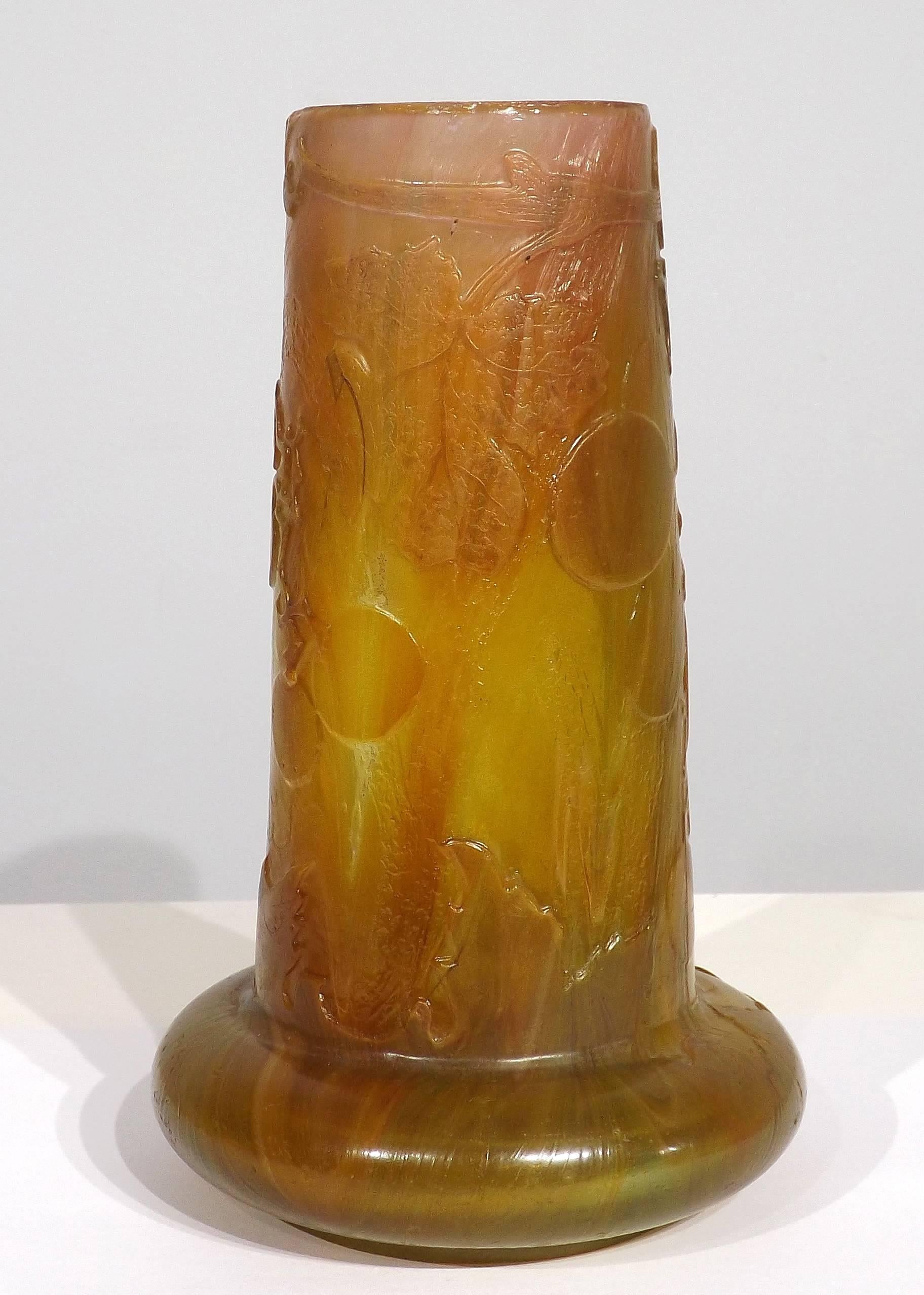 Oval carved cameo vase by Emile Galle´. Squat bulbous base with tapered body in shades of green and amber with internal striations of opalescent rose´. Finely carved stems of the grape vine with entwining tendrils and plump grapes. Intaglio