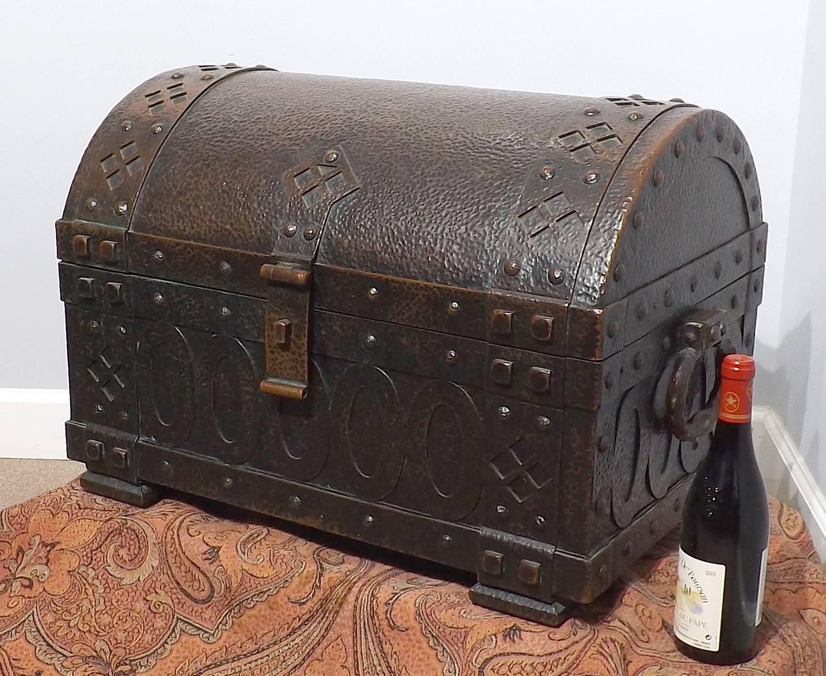 Large heavy hammered copper Arts and Crafts arched top chest. Handmade by a master metalsmith during the late 19th century, of European origin. Heavy strapping’s and large rivets encompass the strongbox. A centered locking clasp adorns the front.