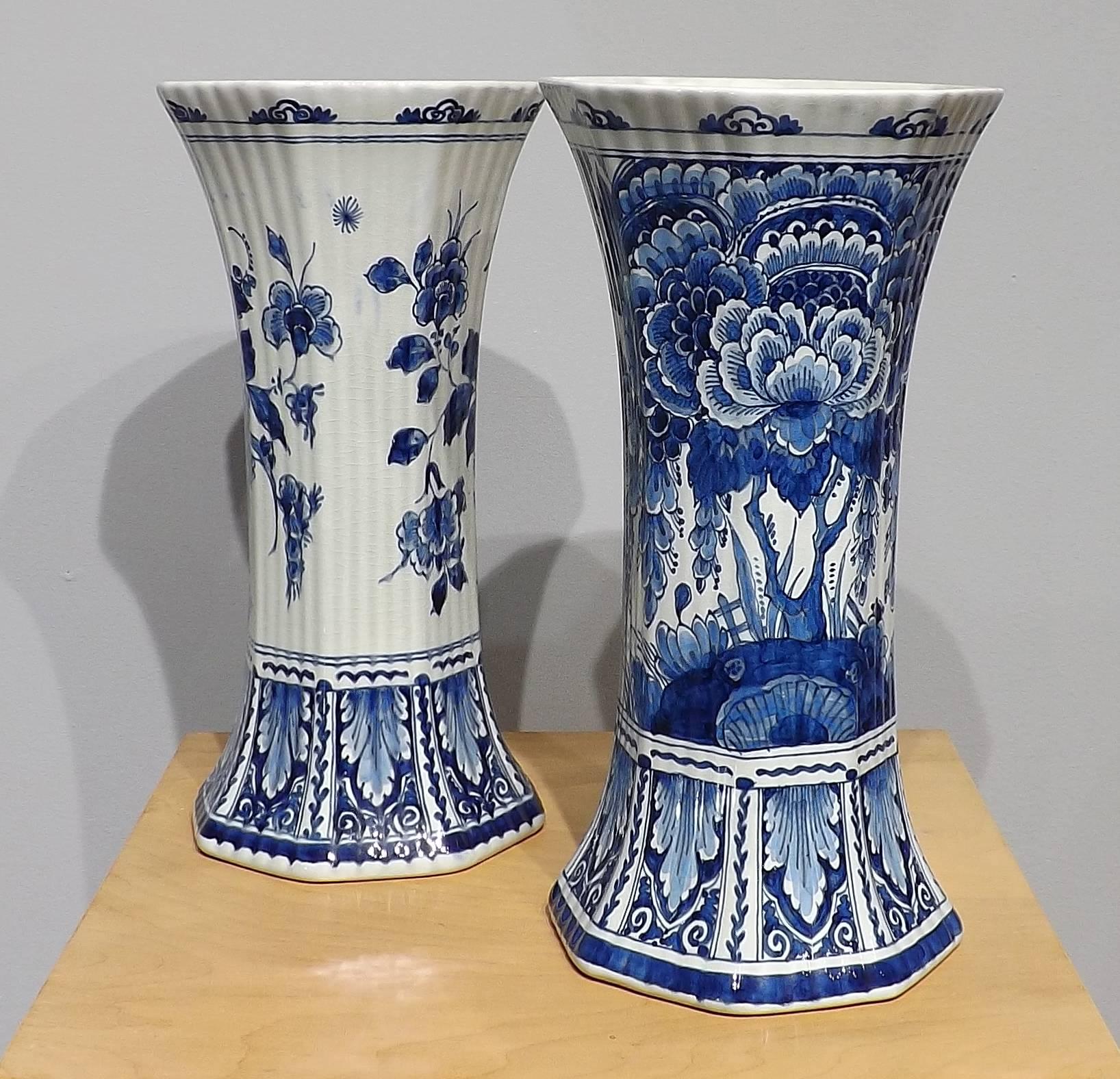 A stunning matched pair of Royal Delft blue vases. Graceful lines extend from the base, across the hand-painted body and up to the flared top. Marked with the bottle mark of De Porcelijne Fles pottery (better known as Royal Delft) and with a year