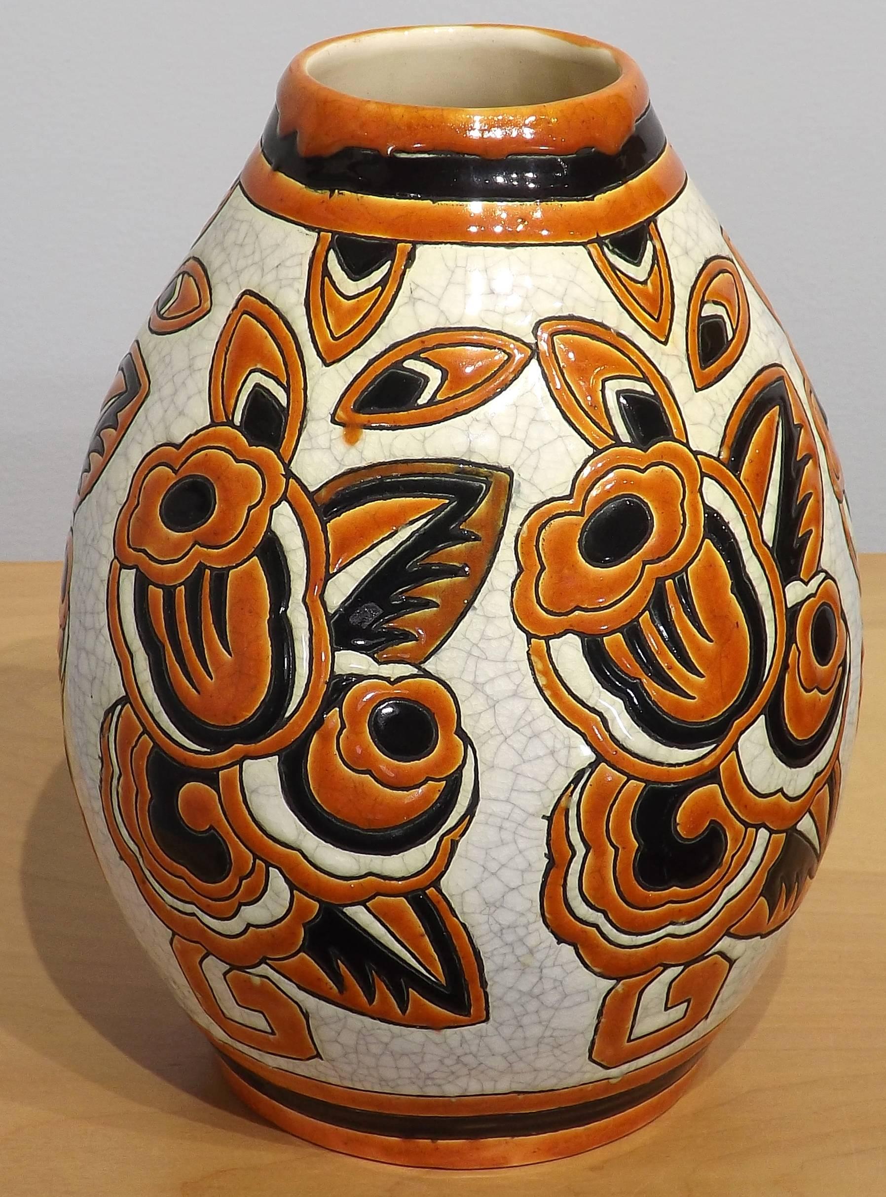 A wonderful hand-painted 9 3/4 inch Boch Freres Keramis vase decorated with flowers painted in earthy colors. The background is a the famous white crazing that Boch Freres is famous for. Gobs of oozing paint, glossy and wet looking appear to flow