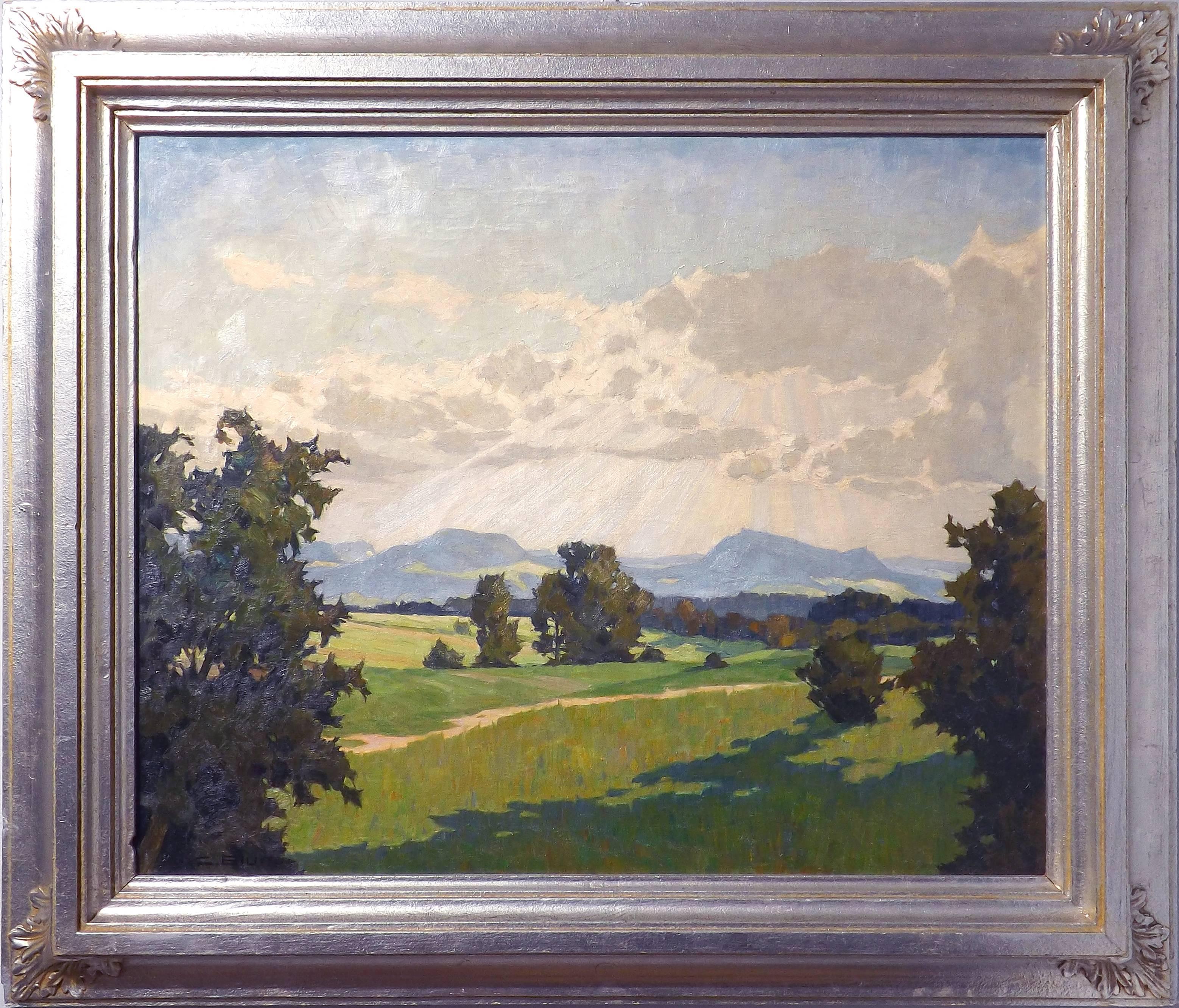 A stunning painting of sunlight breaking through the clouds over rich, green fields. Dark shadows are cast by the trees dotting the landscape, with low mountains rising up in the distance. This painting bears a great resemblance to the Californian