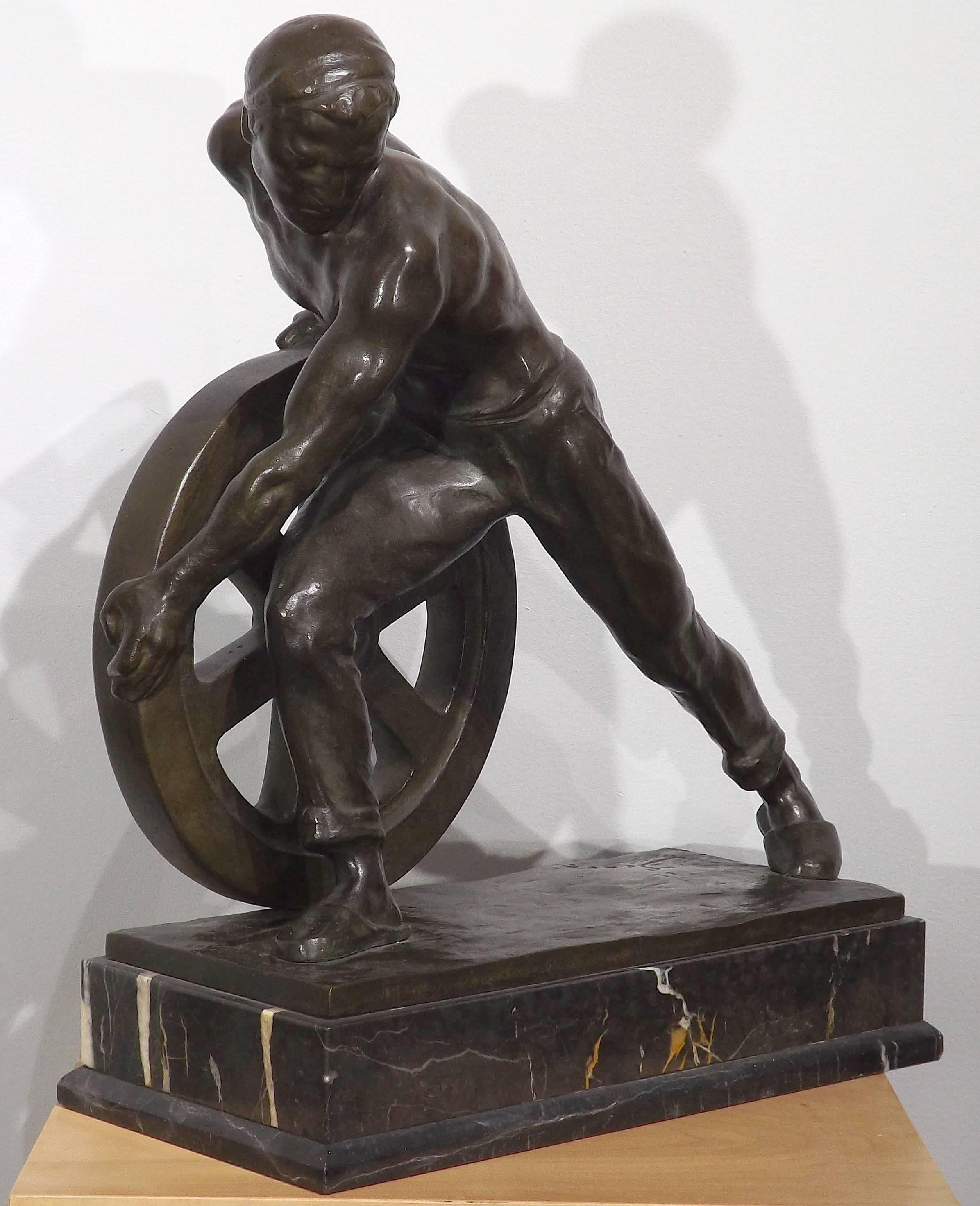 A powerful bronze of a worker laboring hard at pushing a wheel, done by famed German sculptor Ernst Seger (1868-1939). The worker appears to be using every bit of his strength to control the massive wheel, his body stretched to the limits.

Erns