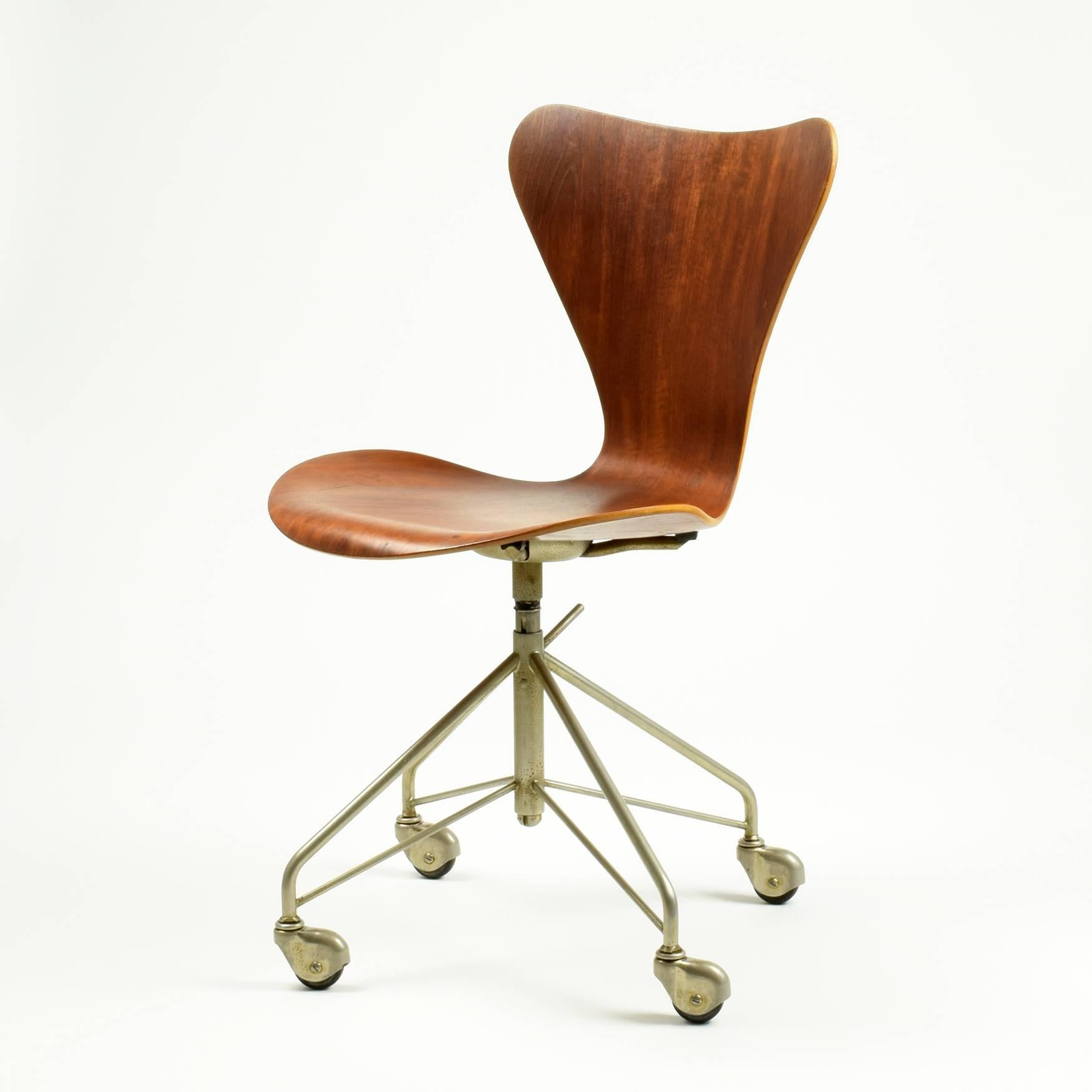Arne Jacobsen

Fritz Hansen (manufacturer), Denmark

Model 3117 desk chair, 1955

Teak veneered plywood, nickel-plated steel, swivel base on castors, height adjustable.

FH (Fritz Hansen) stamped to metal underside of seat.

This is a