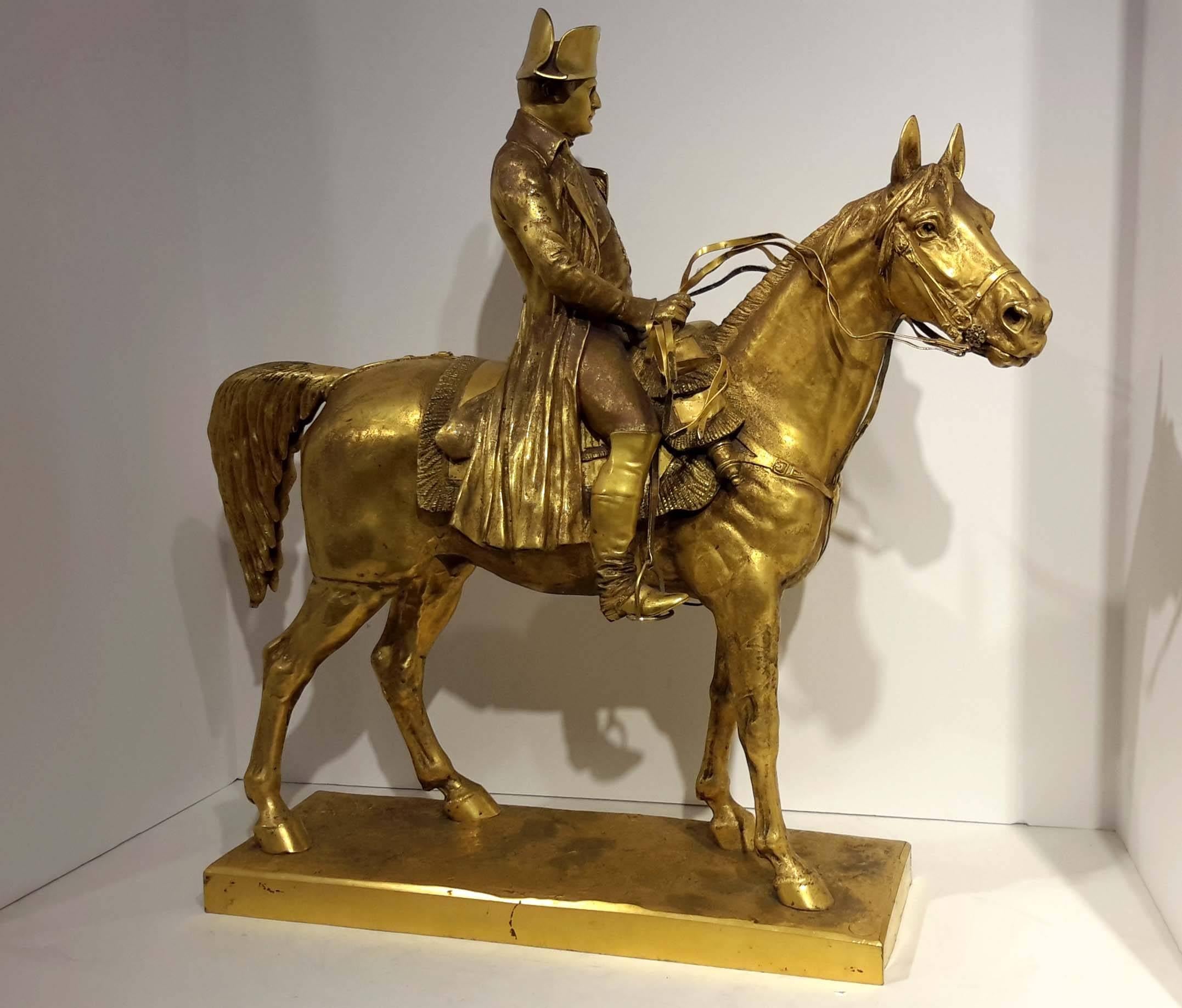 French gilt bronze equestrian mounted figure of Napoleon Bonaparte, the figure wearing a bicorn hat, breeches, vest and long coat, seated on a fringed saddle, cast after Louis-Marie Morise, naturalistic base signed Morise, Pinedo foundry stamp, also