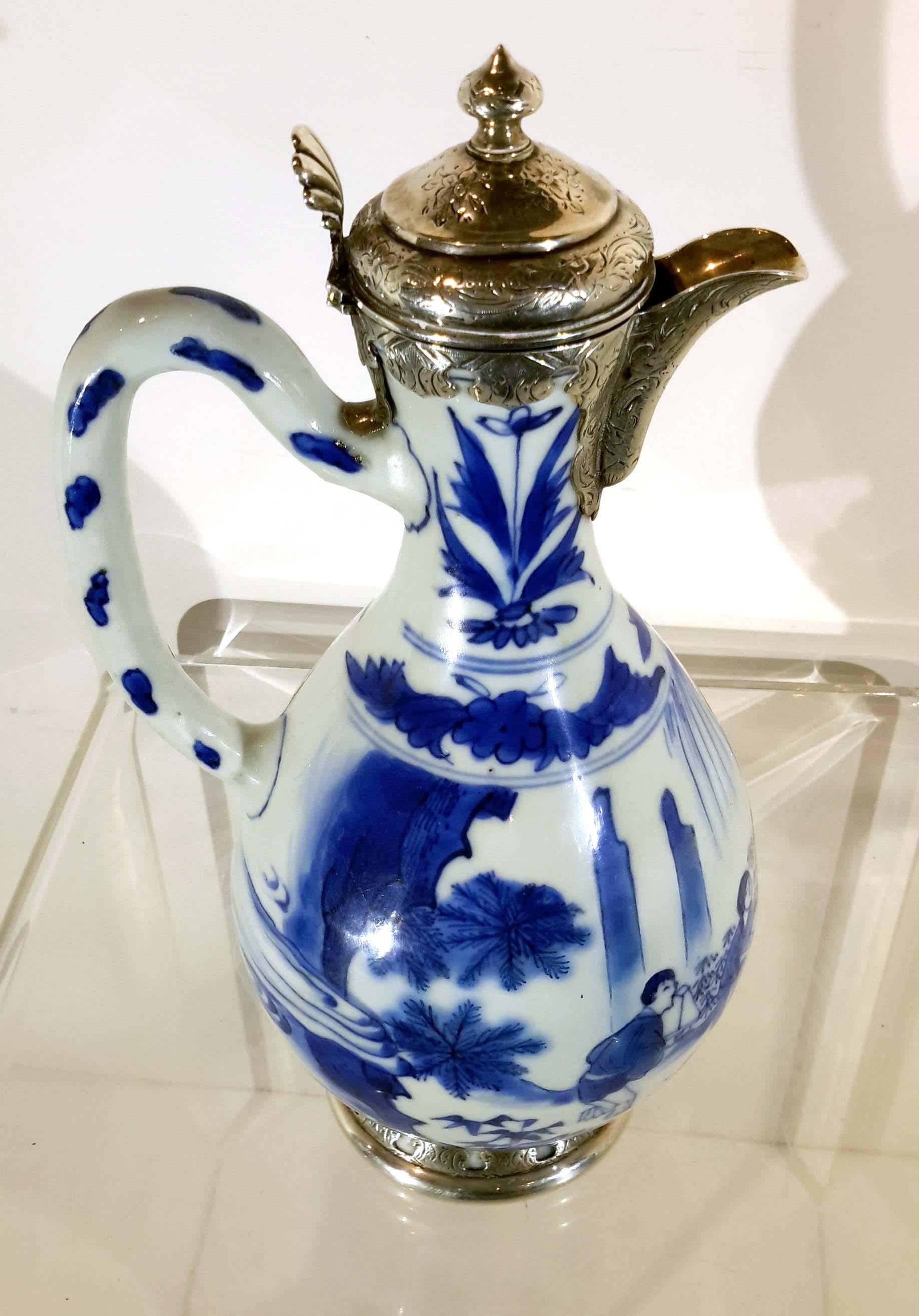 Antique Chinese blue white Ming Dynasty porcelain pitcher with silver mount. An absolutely beautiful piece of porcelain dating to the late 17th century. The form is a tall handled pitcher hand-painted with figures in a landscape. Detail is