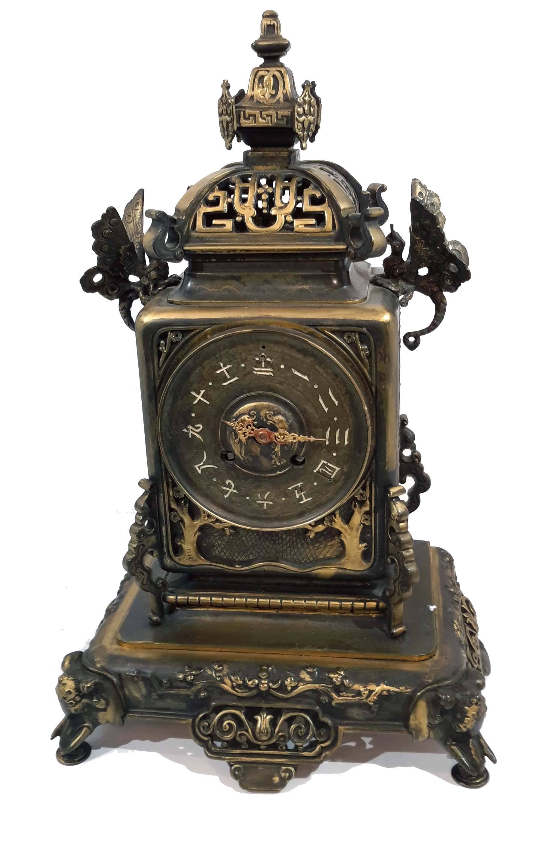 Exotic design possibly by Edouard Lievre, with butterflies and elephant feet.
Gilt decoration an patinated bronze structure.

Measures: Clock high 16 inches, width 10 inches, depth 7 inches
Candelabras high 17 inches, width 9 1/4 inches, depth 5