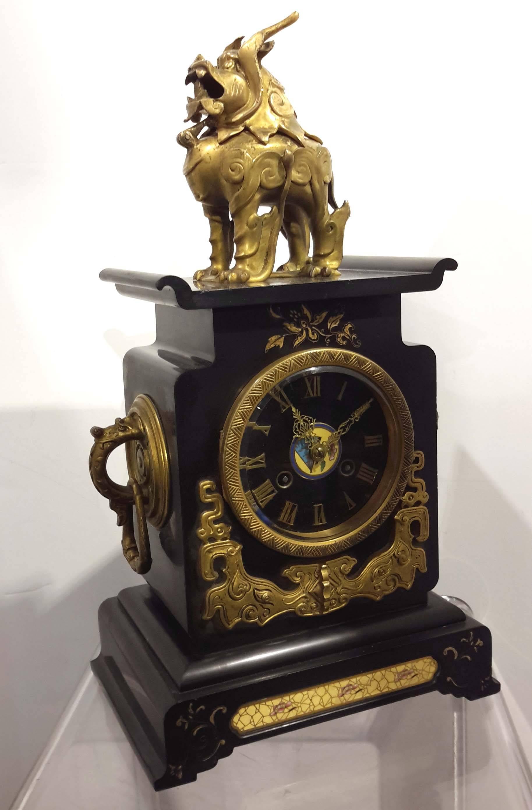 Gilt bronze, cloisonne and black Belgium marble. Movement stamped Tiffany, New York. The bronze foo-dog opens to be used as an incense burner.