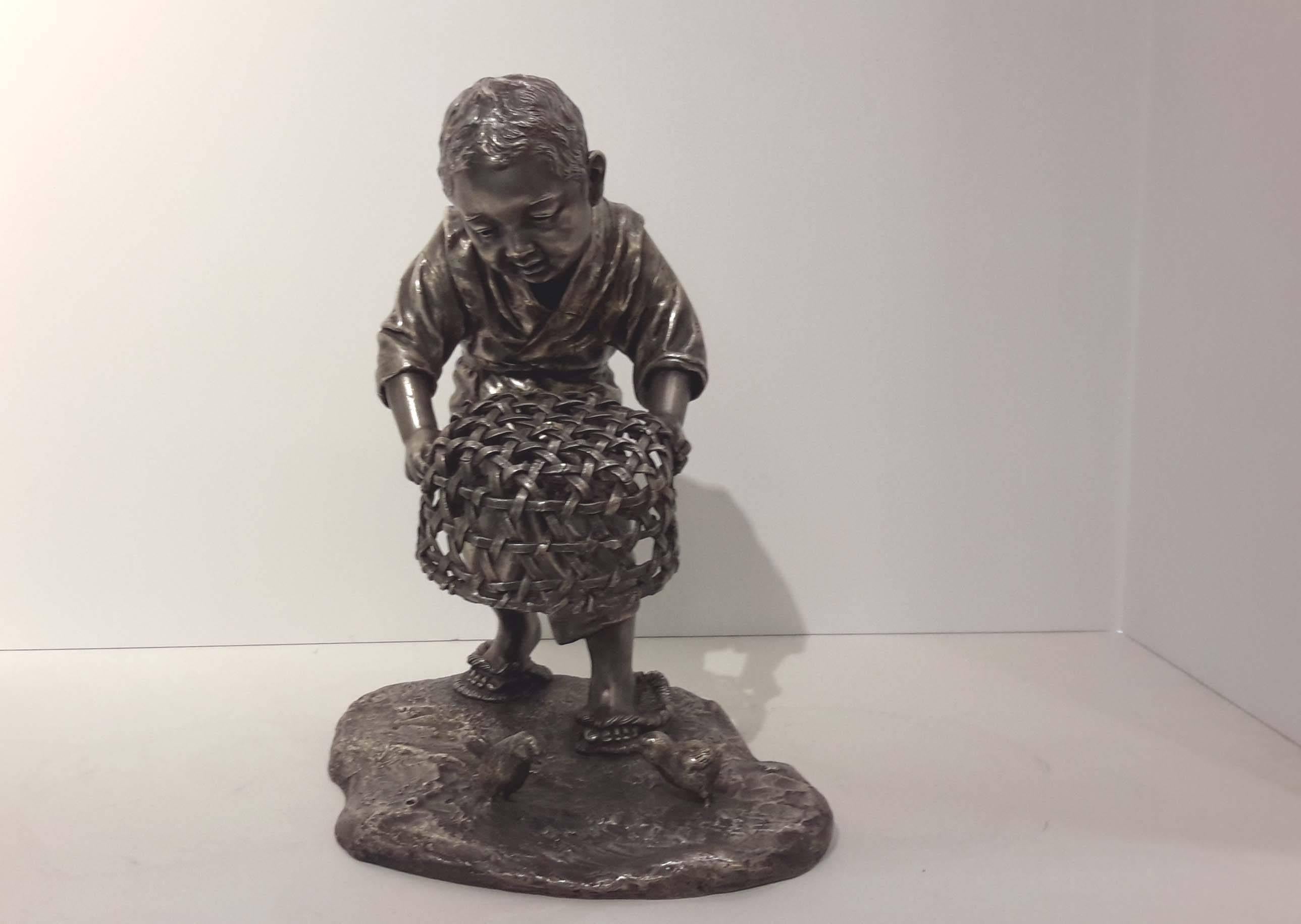 Wonderful cast and silvered bronze figure of a Japanese young boy catching baby chicks with a basket.
Meiji period, circa 1890.