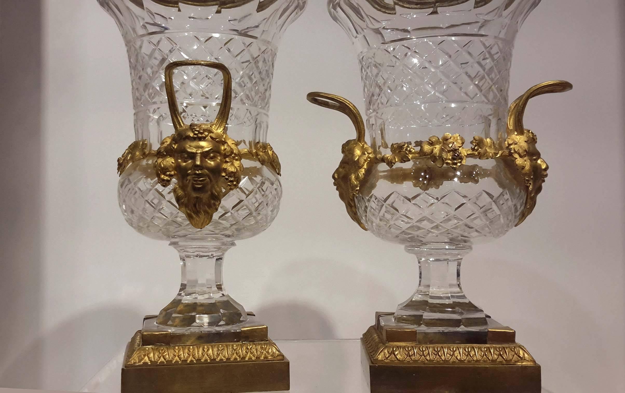 Pair of crystal Campagna form gilt bronze mounted urns , French, Circa 1900.

Decorated with gilt bacchus masks and grape leaves motif.

Approximate Measurements: Height 11 1/4