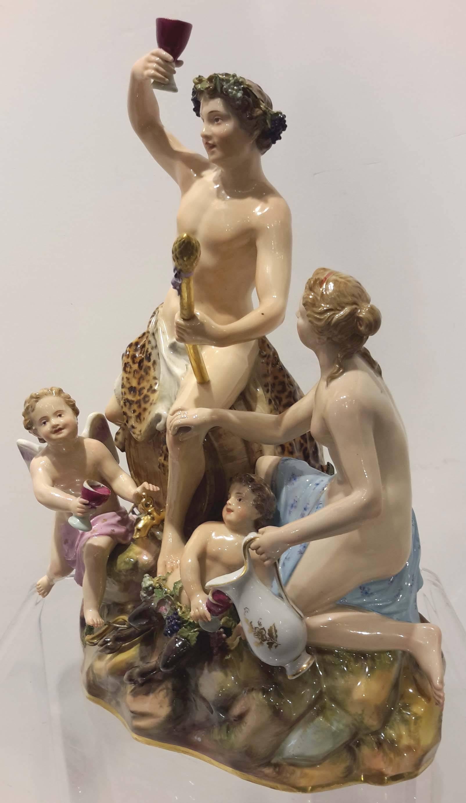 Here is a wonderful large porcelain figurine grouping by Meissen. It features Bacchus sitting atop a wine barrel. He is surrounded by a nymph, a satyr, and a putti. The figure rests on a rock formation. Great workmanship and detail, especially in