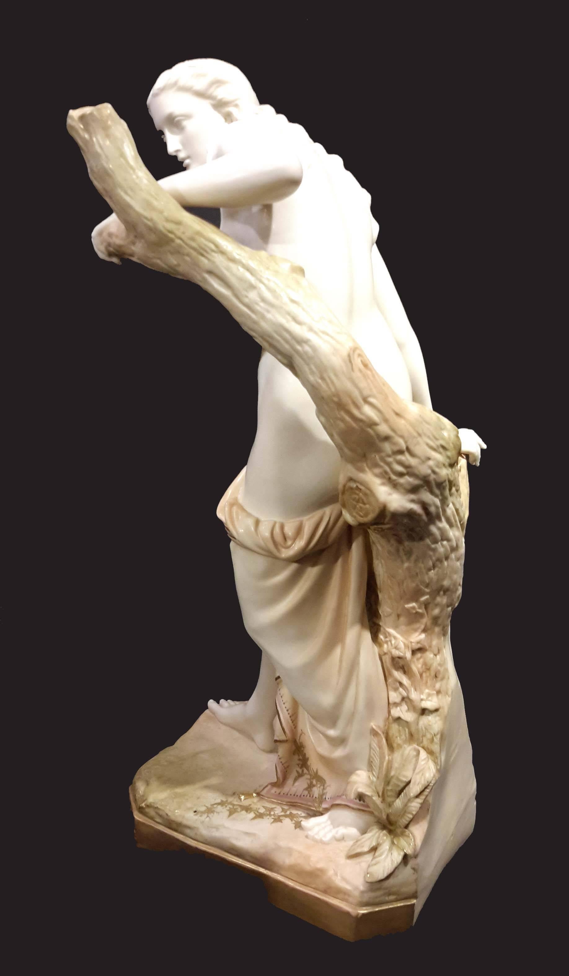 1917, Modelled by Sir Thomas Brock. The semi-draped maiden with gilt robe standing by a gilt tree stump on a rectangular base, (one finger restored), puce mark. This is the largest model of this subject that we found. 25