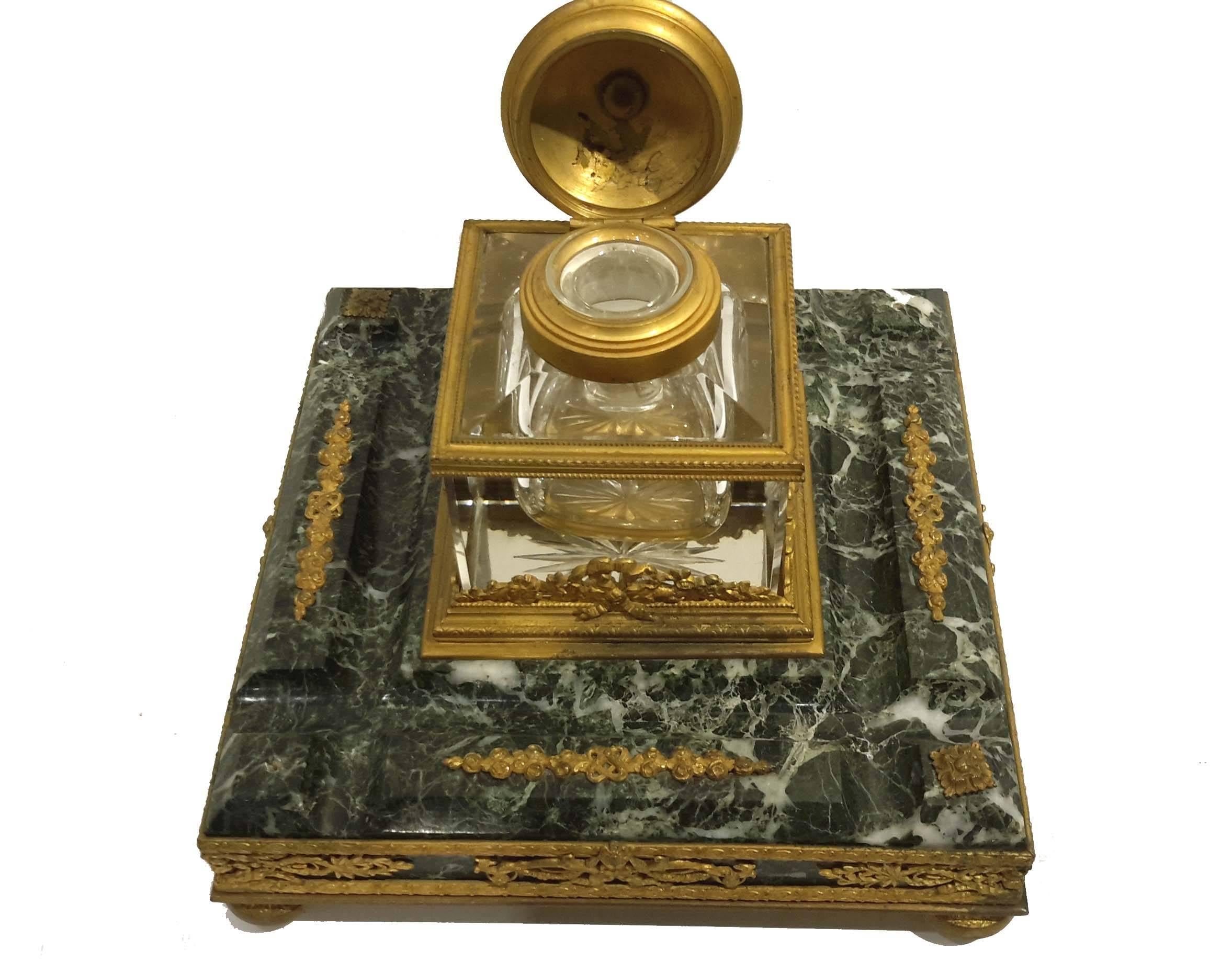 Great quality French inkwell, circa 1890. Intricate bronze work on Verde green carved marble with cut crystal ink container.
Condition: Missing one small rosette. Minor wear to gilding.