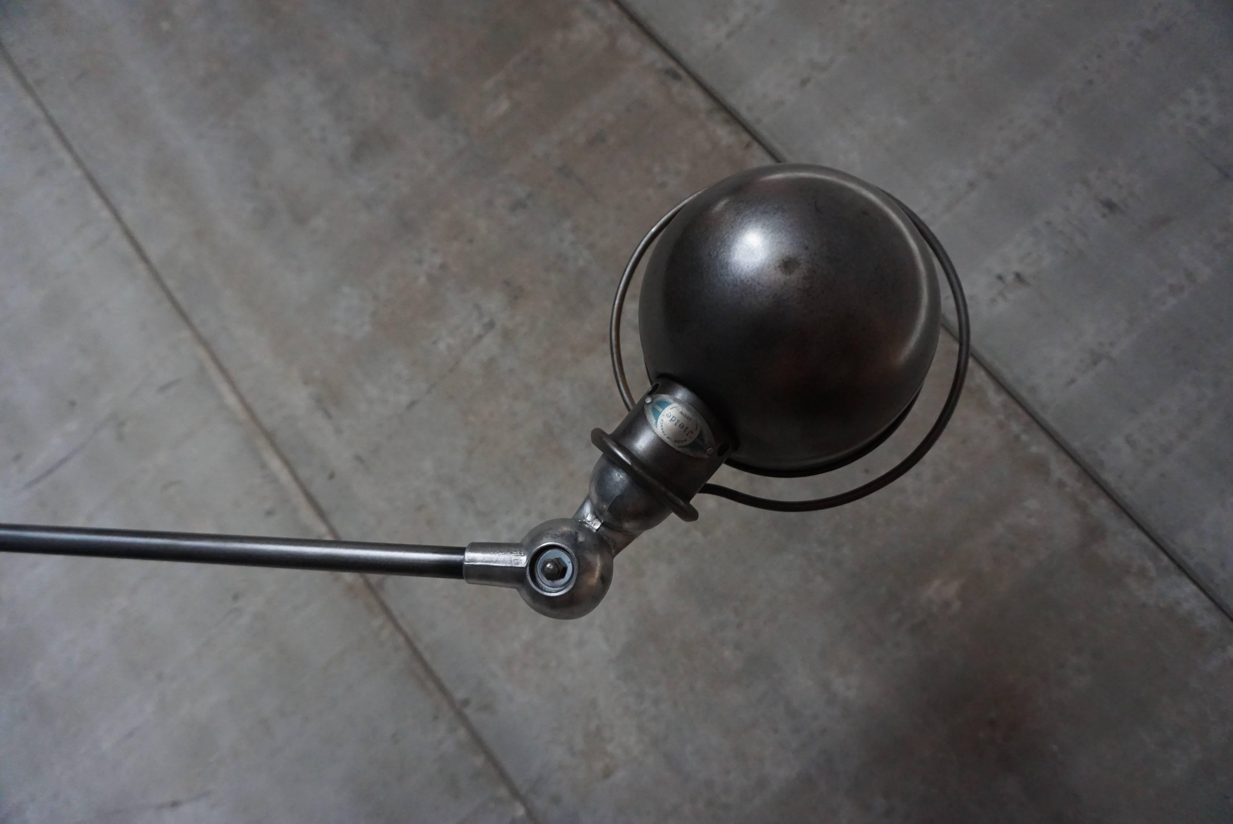 This four-armed Industrial lamp was manufactured by Jieldé in Lyon, France during the 1950s. The lamp is mounted on a clean brake disk. Each arm of the light measures 40cm. The metal is brushed and treated with graphite wax. It has been fully
