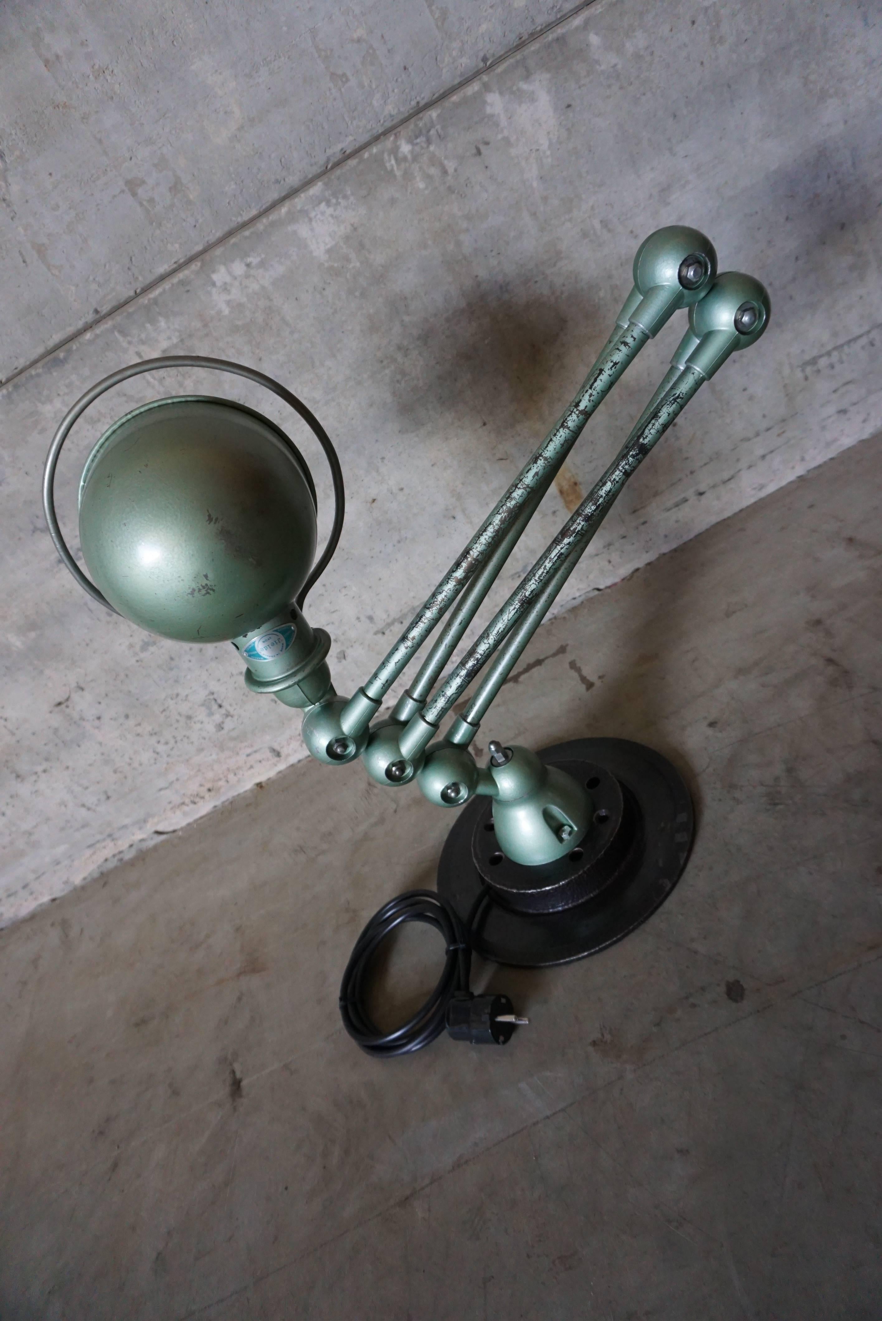 This four-armed Industrial lamp was manufactured by Jieldé in Lyon, France during the 1950s following a design by Jean-Louis Domecq. The lacquered-metal lamp is mounted on a clean brake disk.