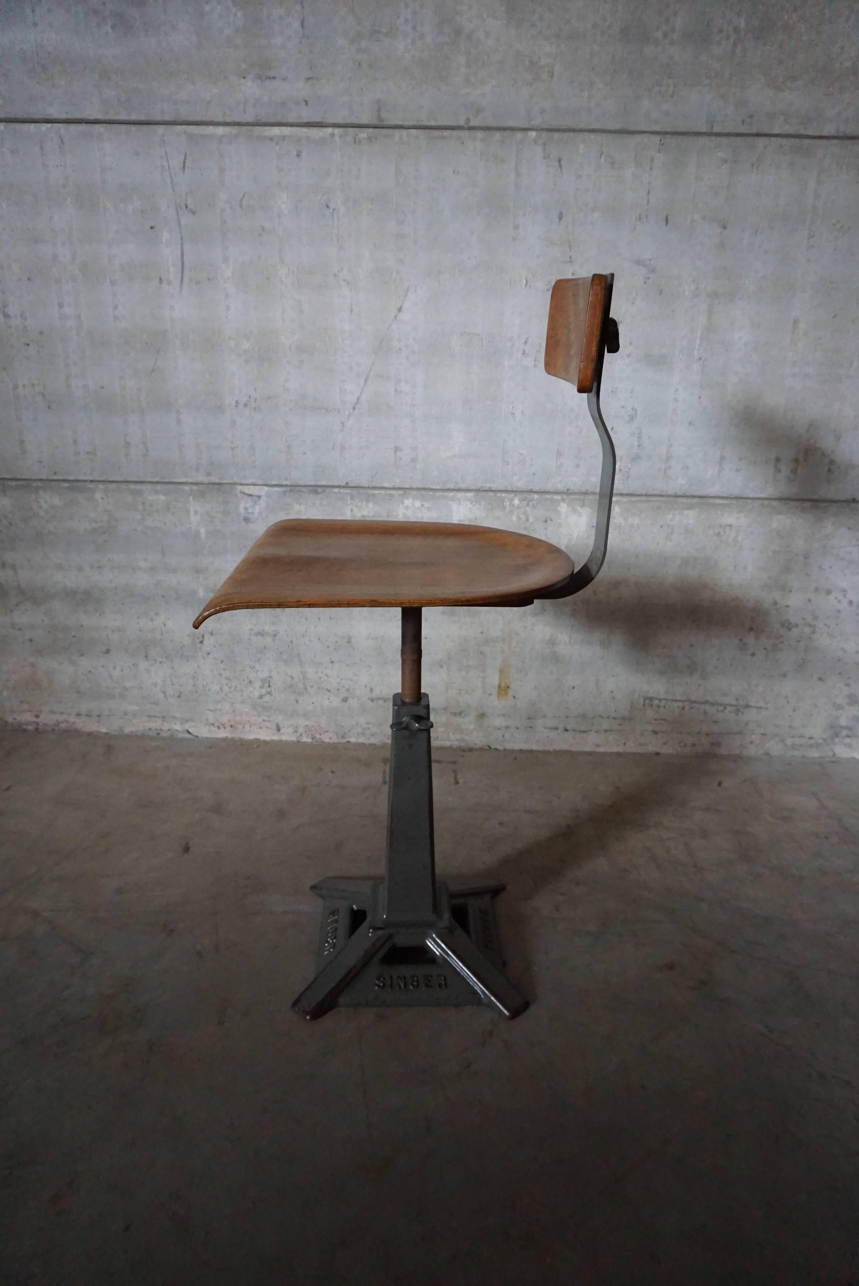 Singer machinist or work chairs. Branded cast iron base with factory painted finish, steam bent ply seat and backrest. Manufactured by “Simanco” the Singer manufacturing company England, 1930s.