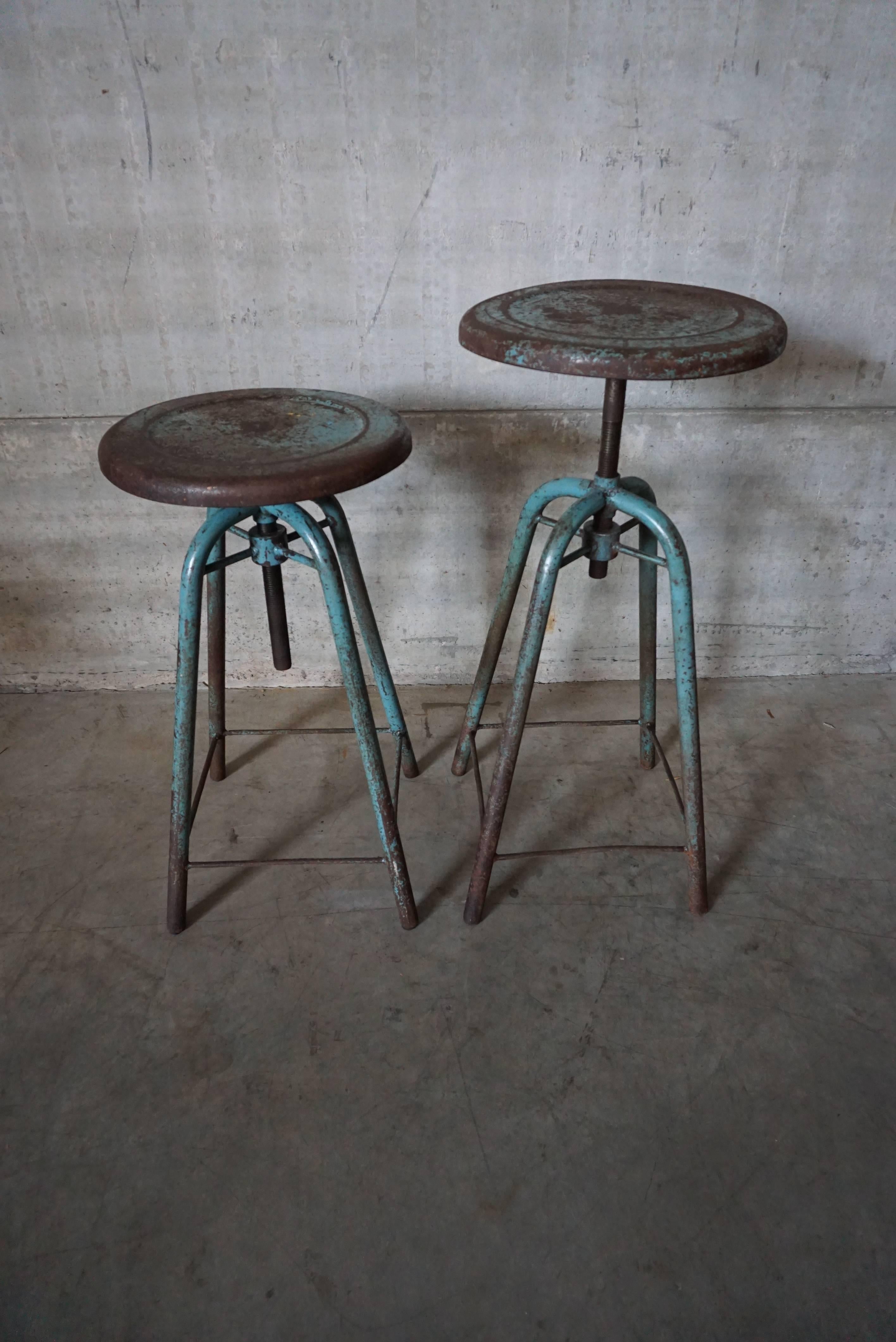This pair of French Industrial stools were made in France in the 1950s. They feature a metal frame and in height adjustable seat.