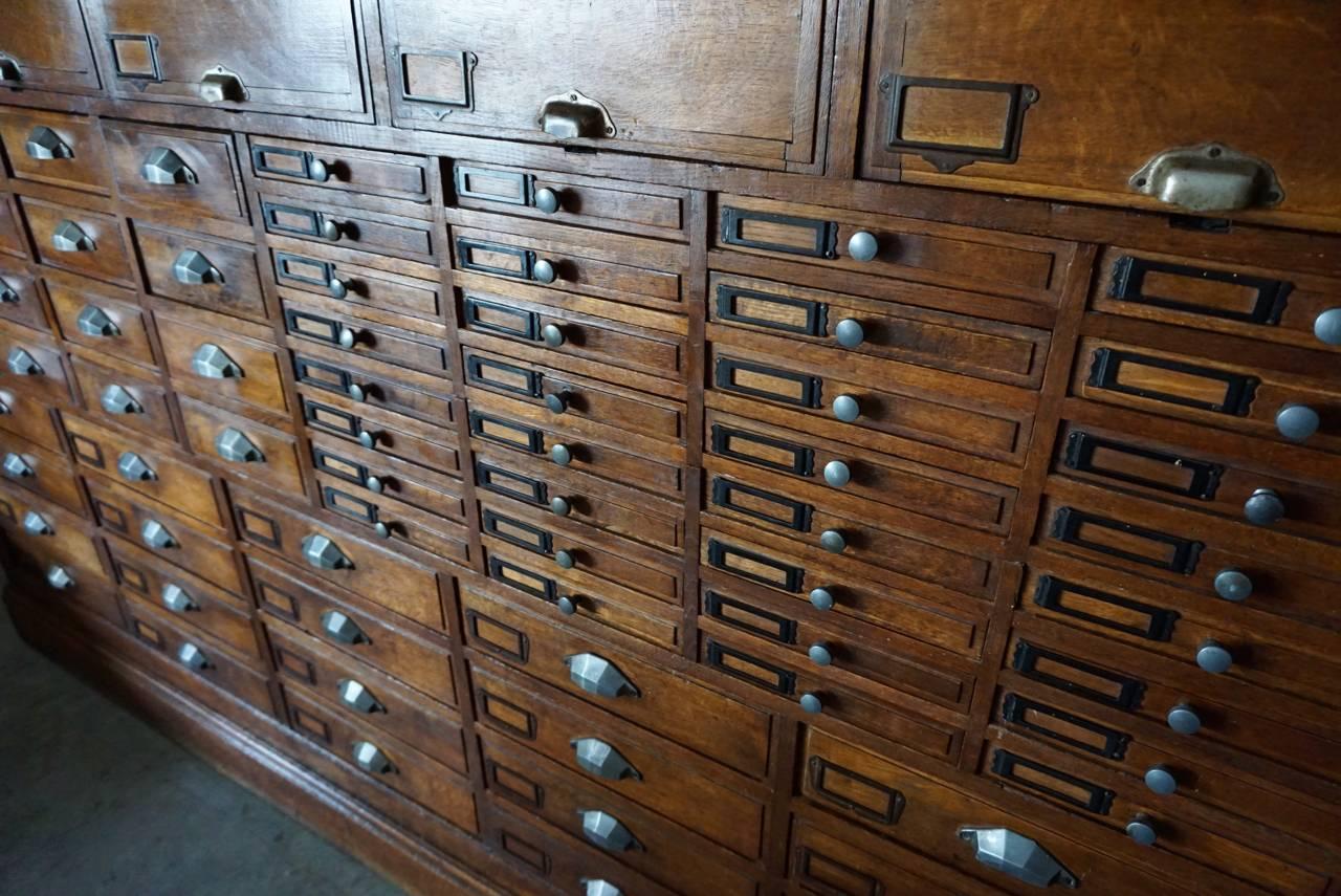 This oak jewelers’ cabinet was made and designed in the 1930s in France. It features a selection of drawers in different sizes and ten large compartments in the top and is made of two pieces. It was salvaged from a jeweler store in Paris that was