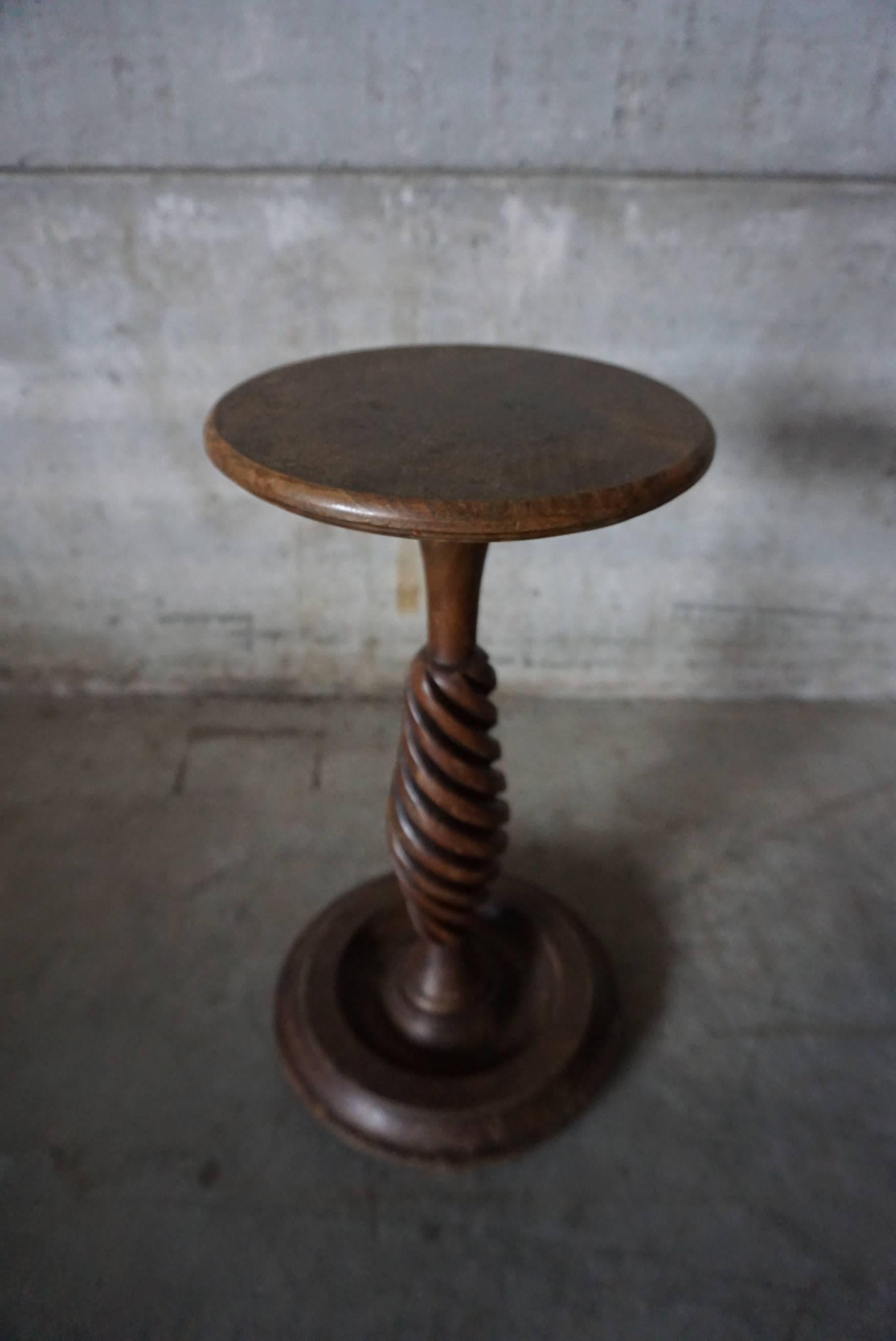 This antique oak pedestal was designed and made in the early 20th century in France. It features an oak top and base with a turned leg.