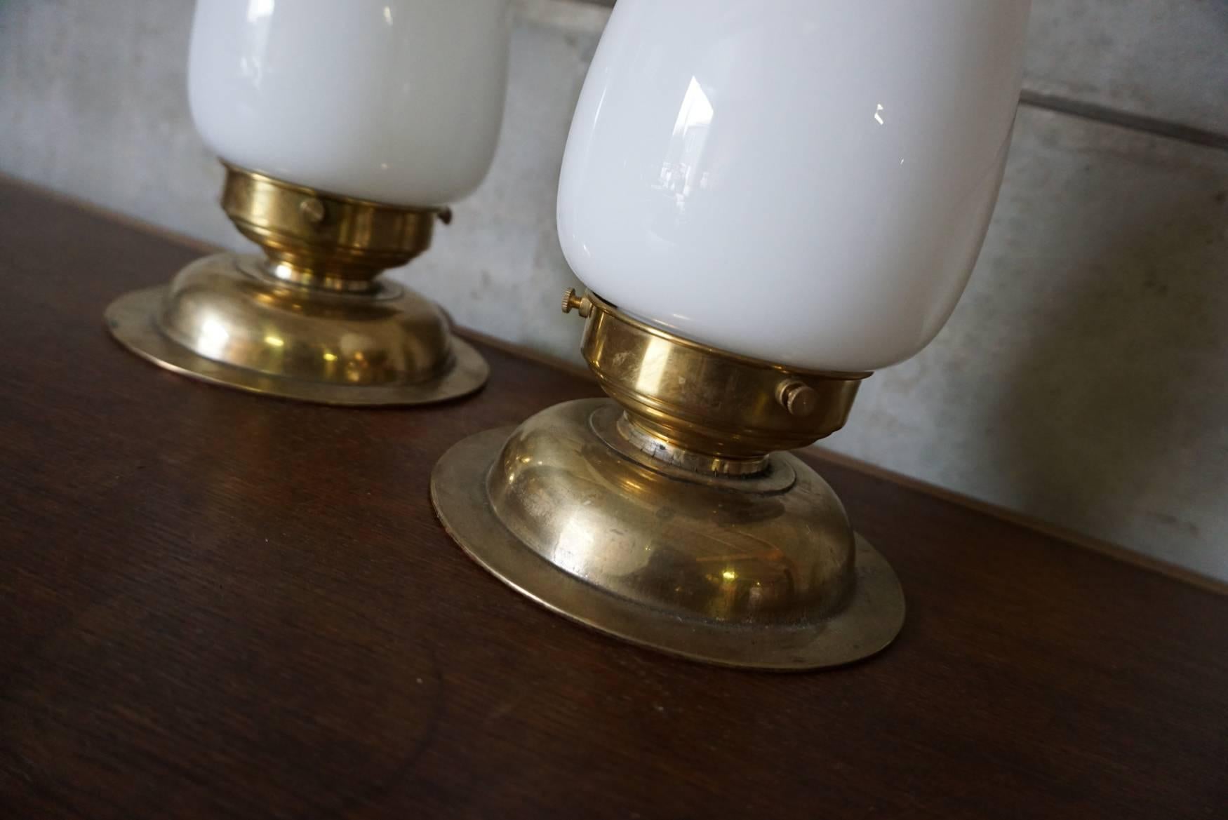 This pair of table lamps were designed between 1920-1930 and produced in Germany. The base is made of brass with glass shades. The lights are in good condition with only minor signs of wear. They are equipped with E27 sockets and rewired.