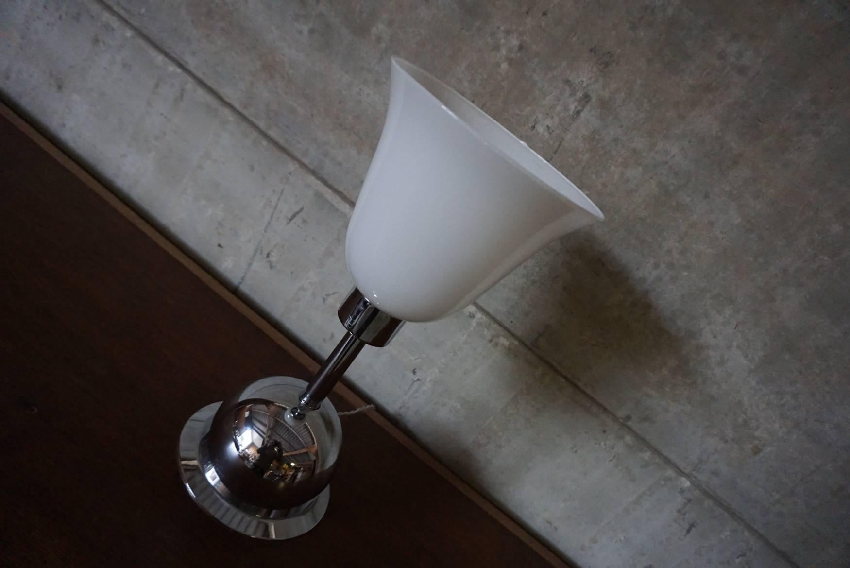 This table lamp was designed around the 1930s and produced in Germany. The base is made of chrome-plated metal with a glass shade. The light is in good condition with only minor signs of wear and it is equipped with E27 sockets and rewired.