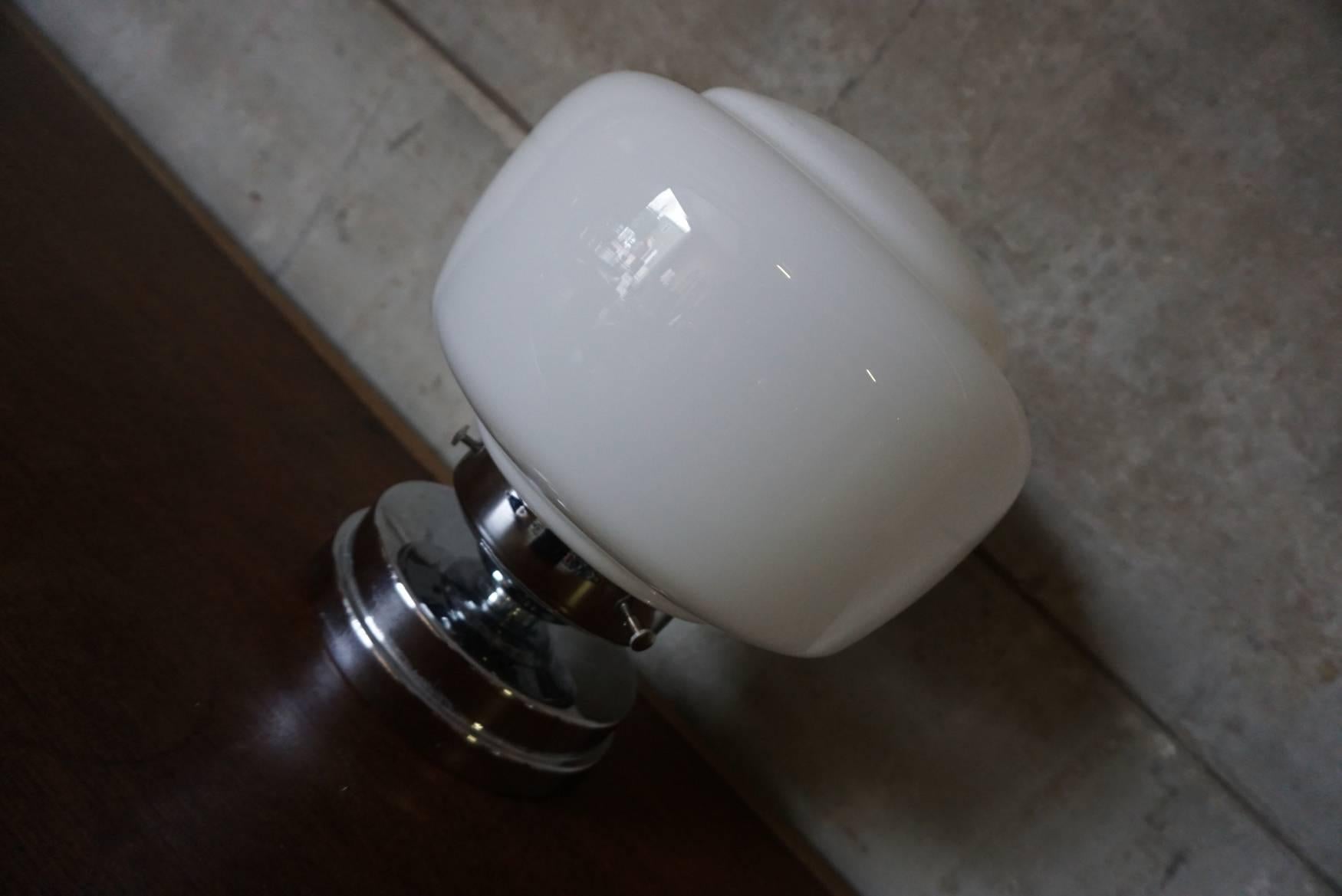 This table lamp was designed around the 1930s and produced in Germany. The base is made of chrome plated metal with a glass shade. The light is in good condition with only minor signs of wear and it is equipped with a E27 sockets and rewired.