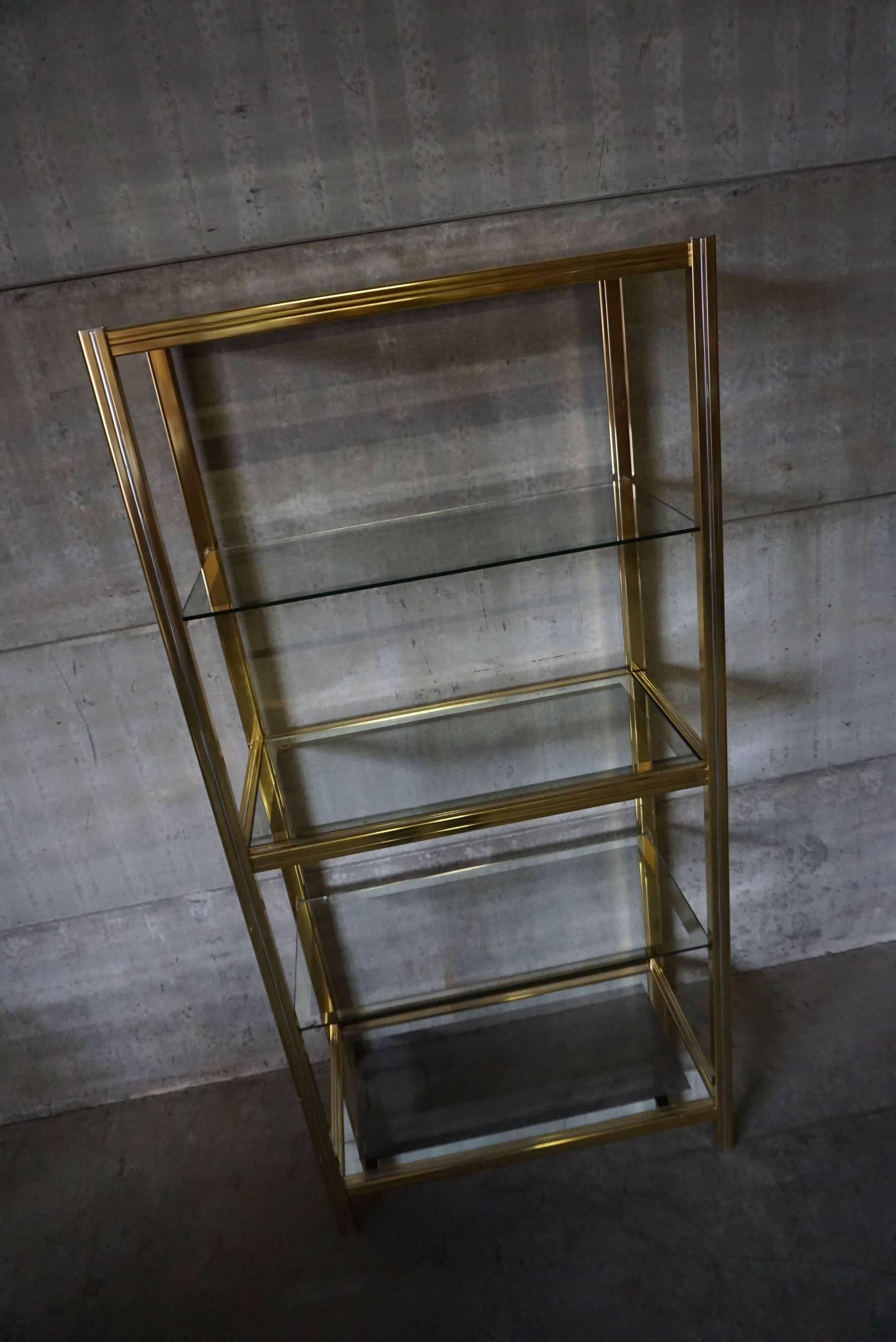 This vintage shelving unit was designed in the 1970s in Italy. It is made from polished brass and features glass shelves.