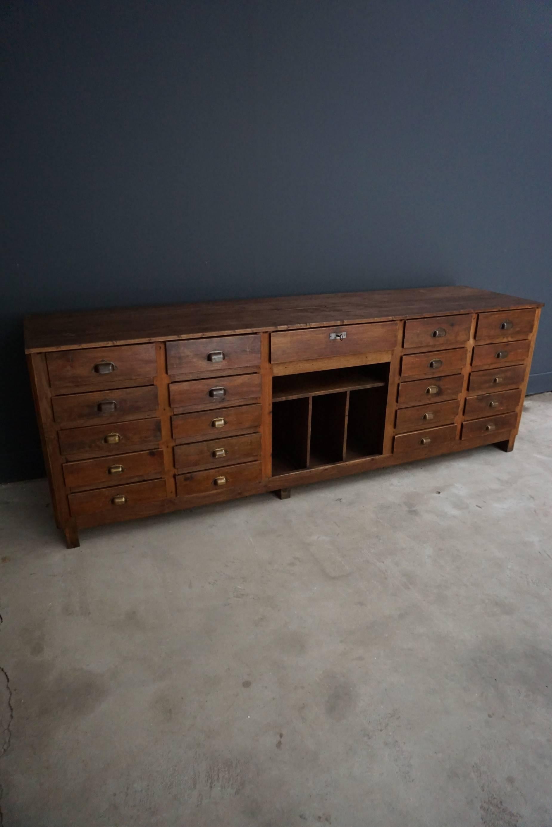 This restored apothecary bank of drawers was designed and made around the 1950s. It is made from pine and features different drawers and shelves. It was previously used as a shop counter.