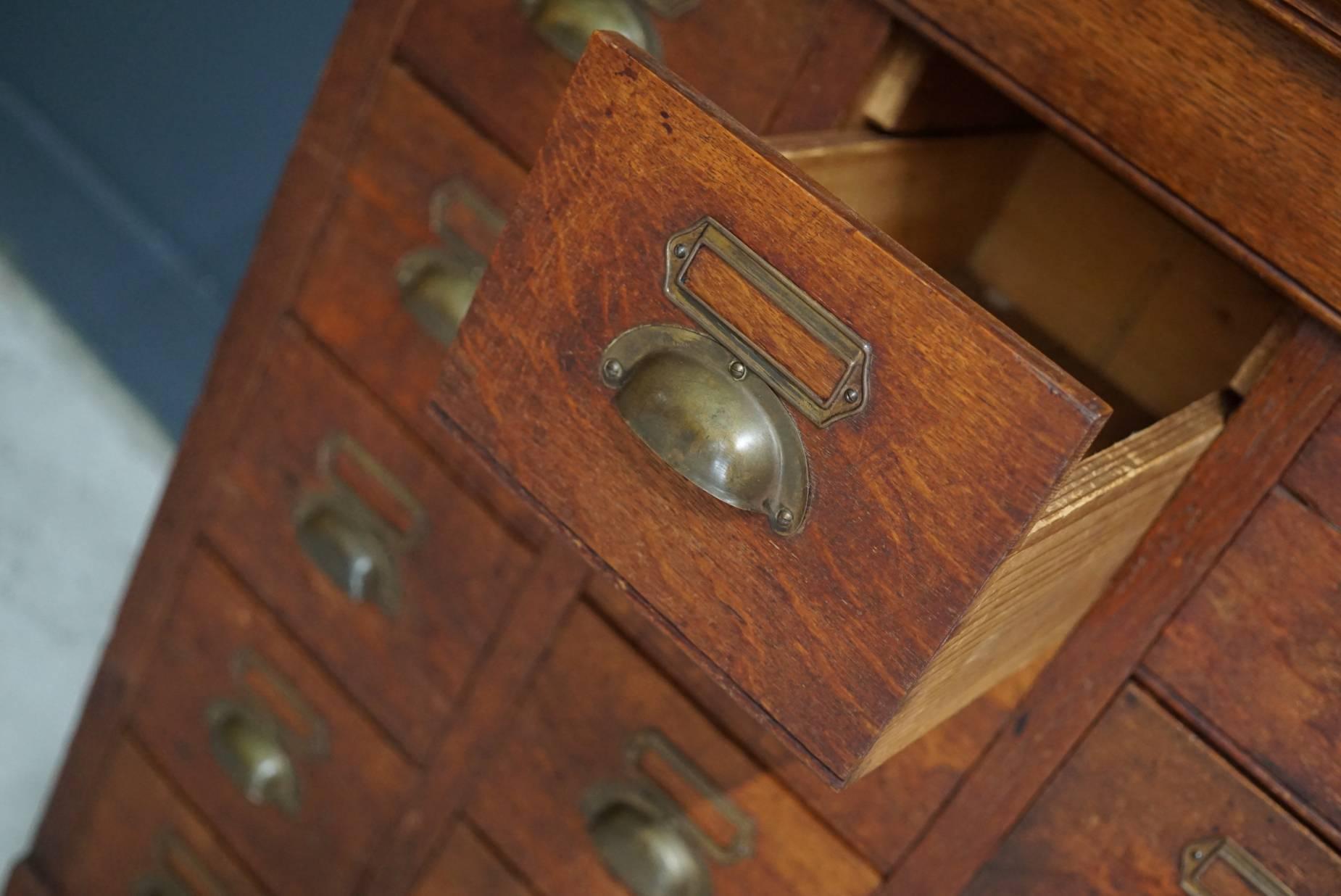 This apothecary bank of drawers was designed and made circa 1930s in France. The piece is made from oak and brass hardware. It remains in a nice patinated condition.