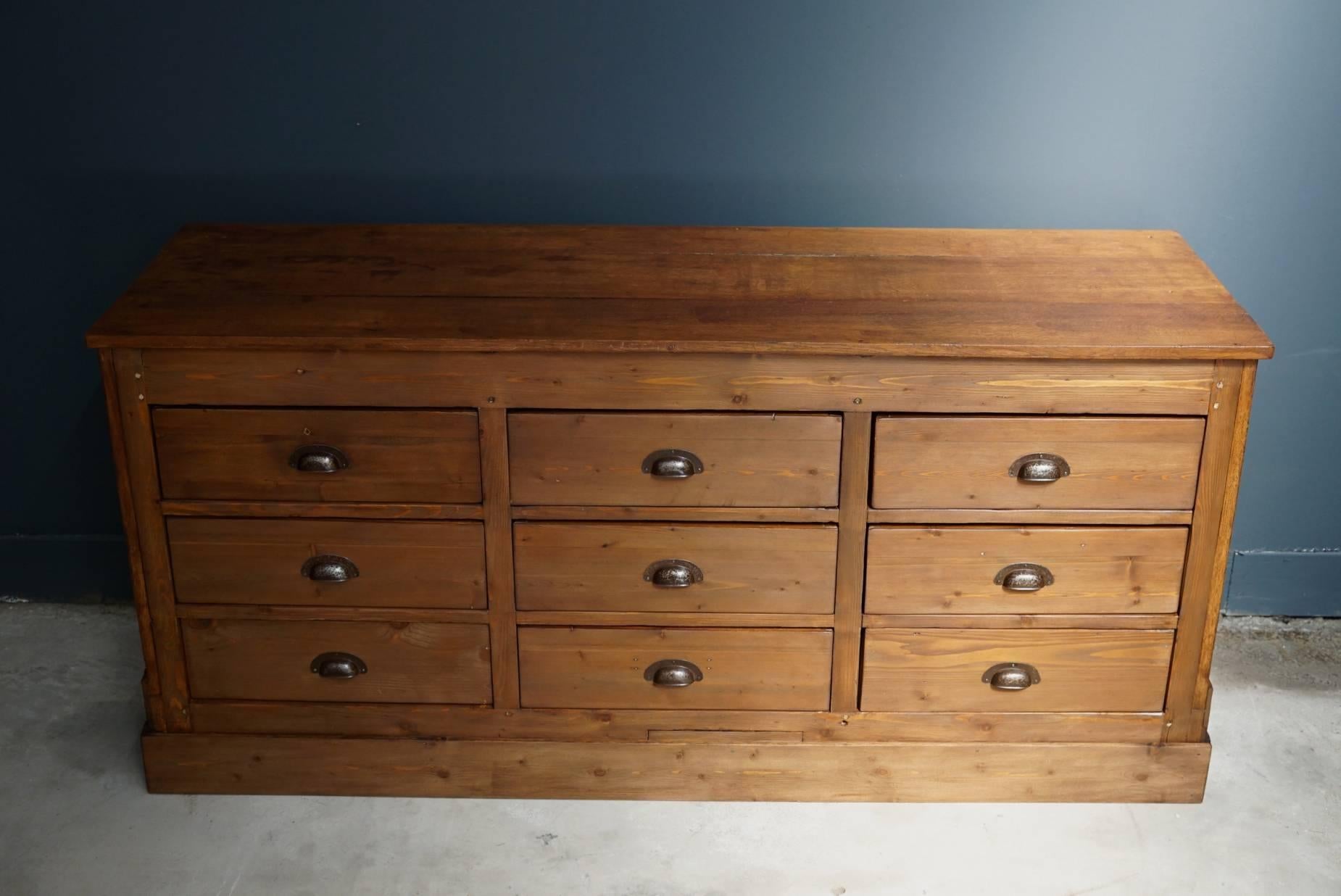 This apothecary bank of drawers was designed and made circa 1930s in France. The piece is made from pine and oak paneled sides and back and drawers with metal cup handles.