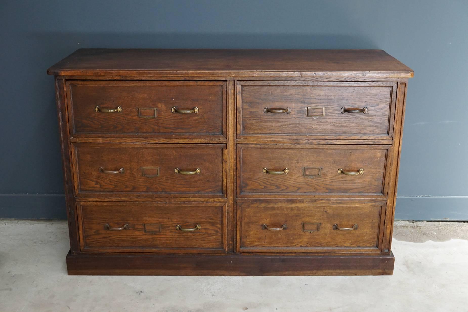 This apothecary bank of drawers was designed, circa 1900s in the United Kingdom. The piece is made from oak and features 6 drawers with brass hardware.