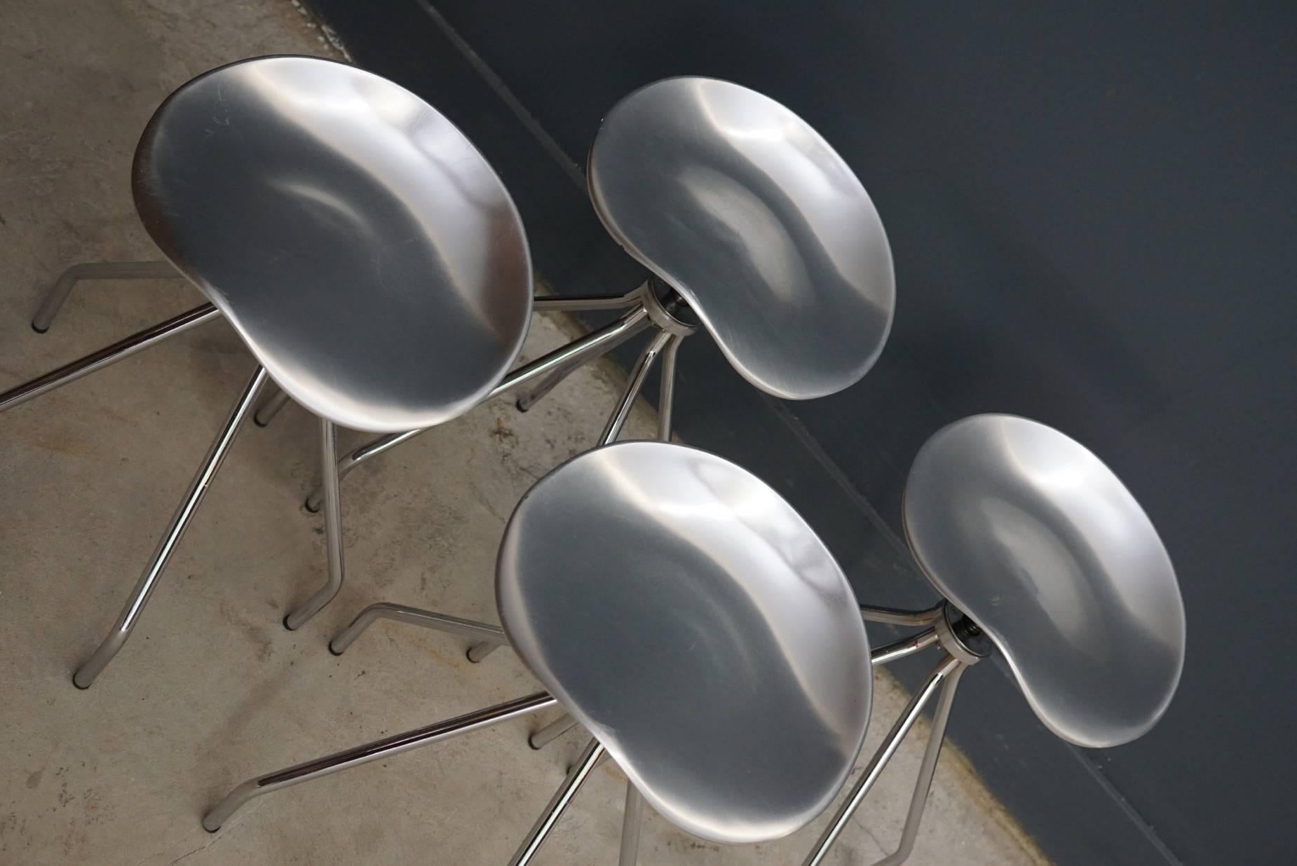 Set of four edition stools designed by Pepe Cortes and made in Spain by Amat-3 for Knoll. Aluminum saddle-like seats which swivel and chrome frames. In very good vintage condition. The seat height can be adjusted from 45 to 55 cm.