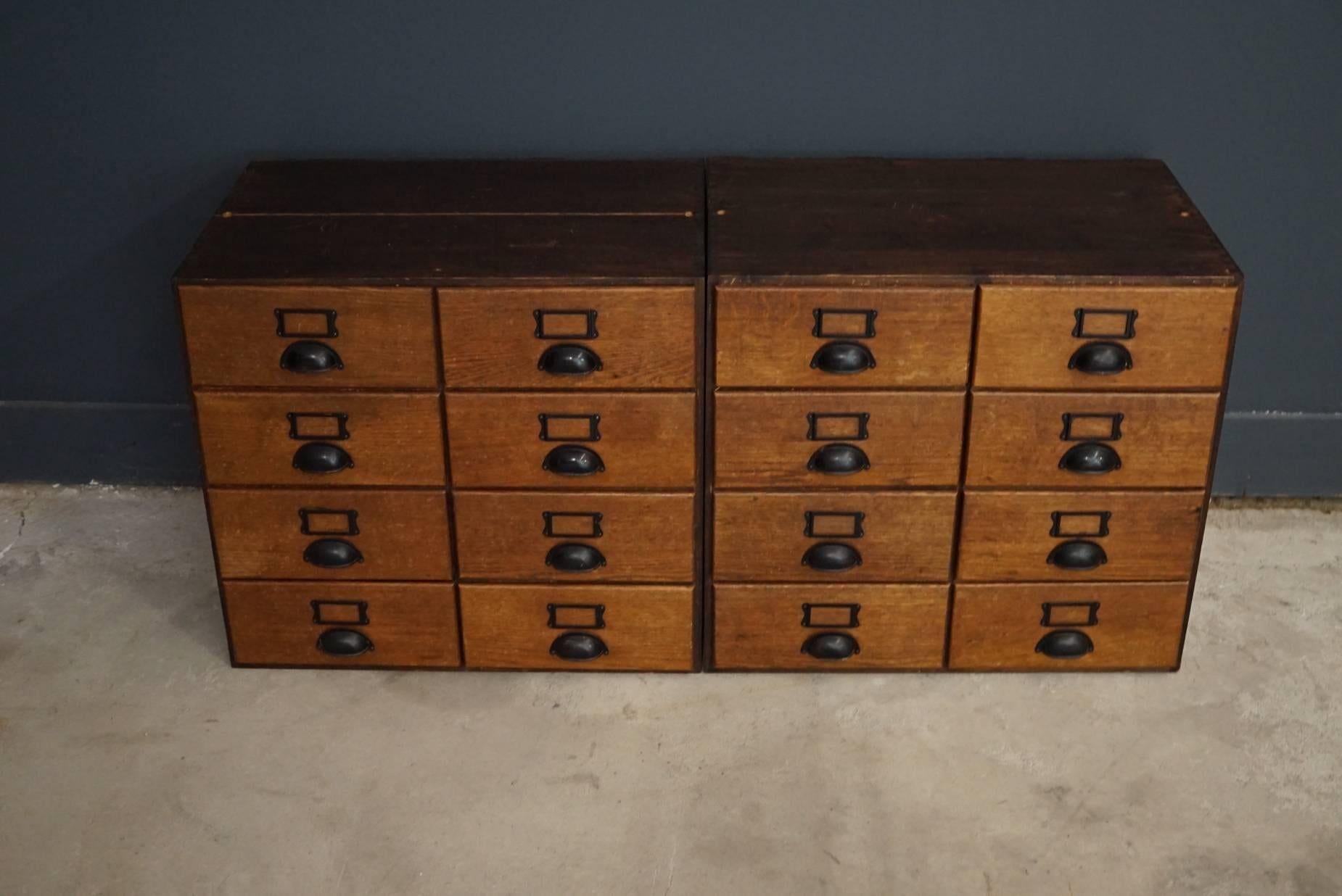 This pair of apothecary cabinets were designed and made, circa 1950s in Germany. The cabinets are made from oak and pine and feature drawers with metal cup handles.