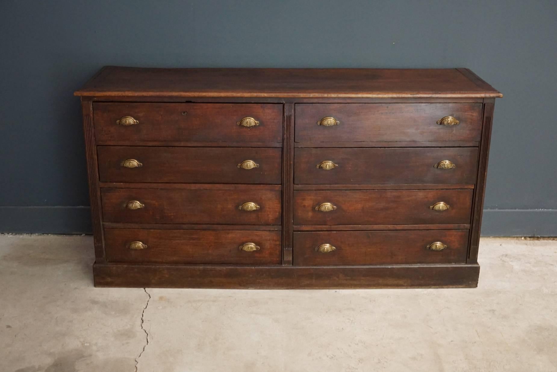 This apothecary cabinet of drawers was designed, circa 1920s in France. The piece is made from oak and features eight large drawers with brass handles.