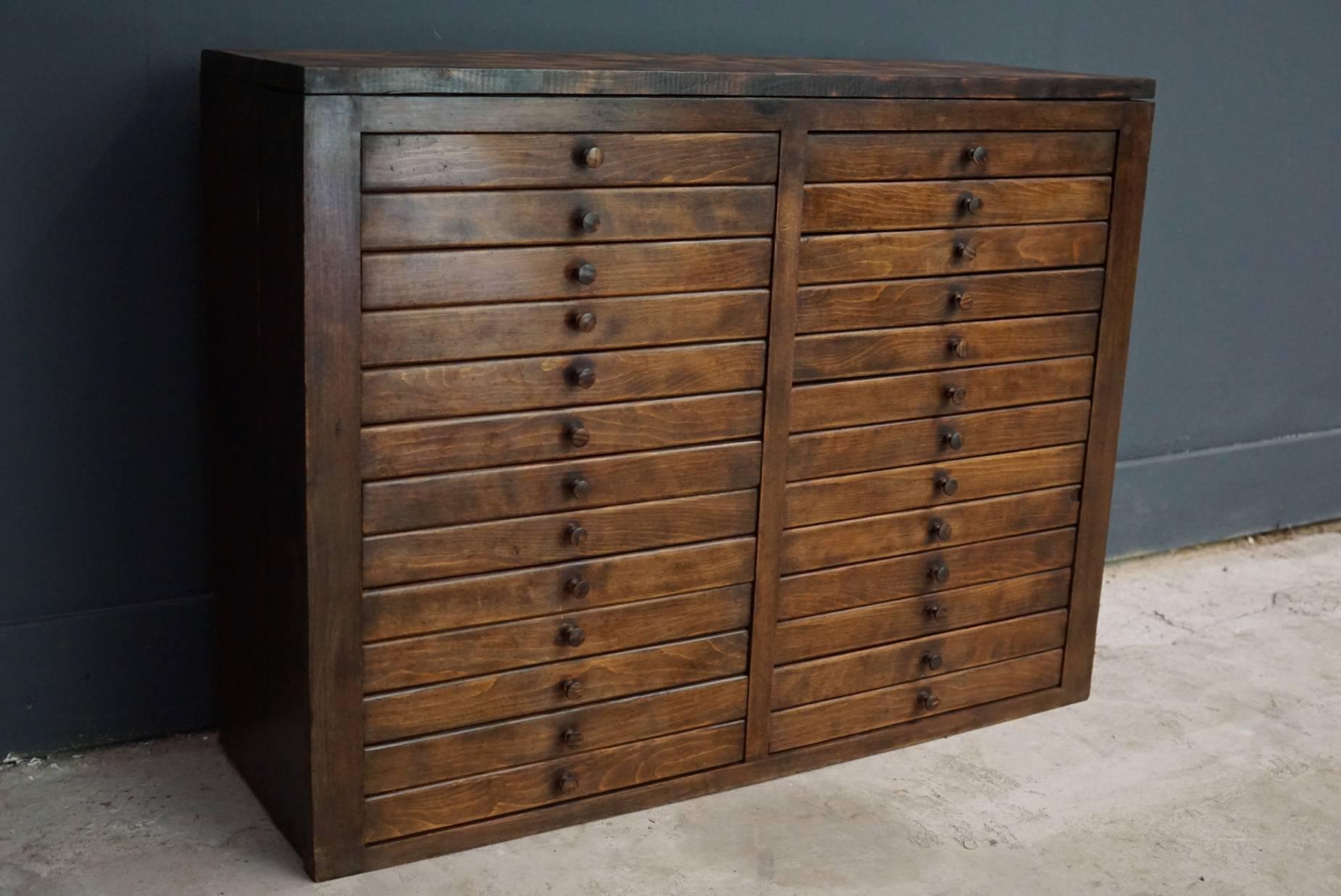 This pine jewelers cabinet was designed and made circa 1950s in France. It features 26 drawers with wooden knobs. It remains in a good vintage condition.