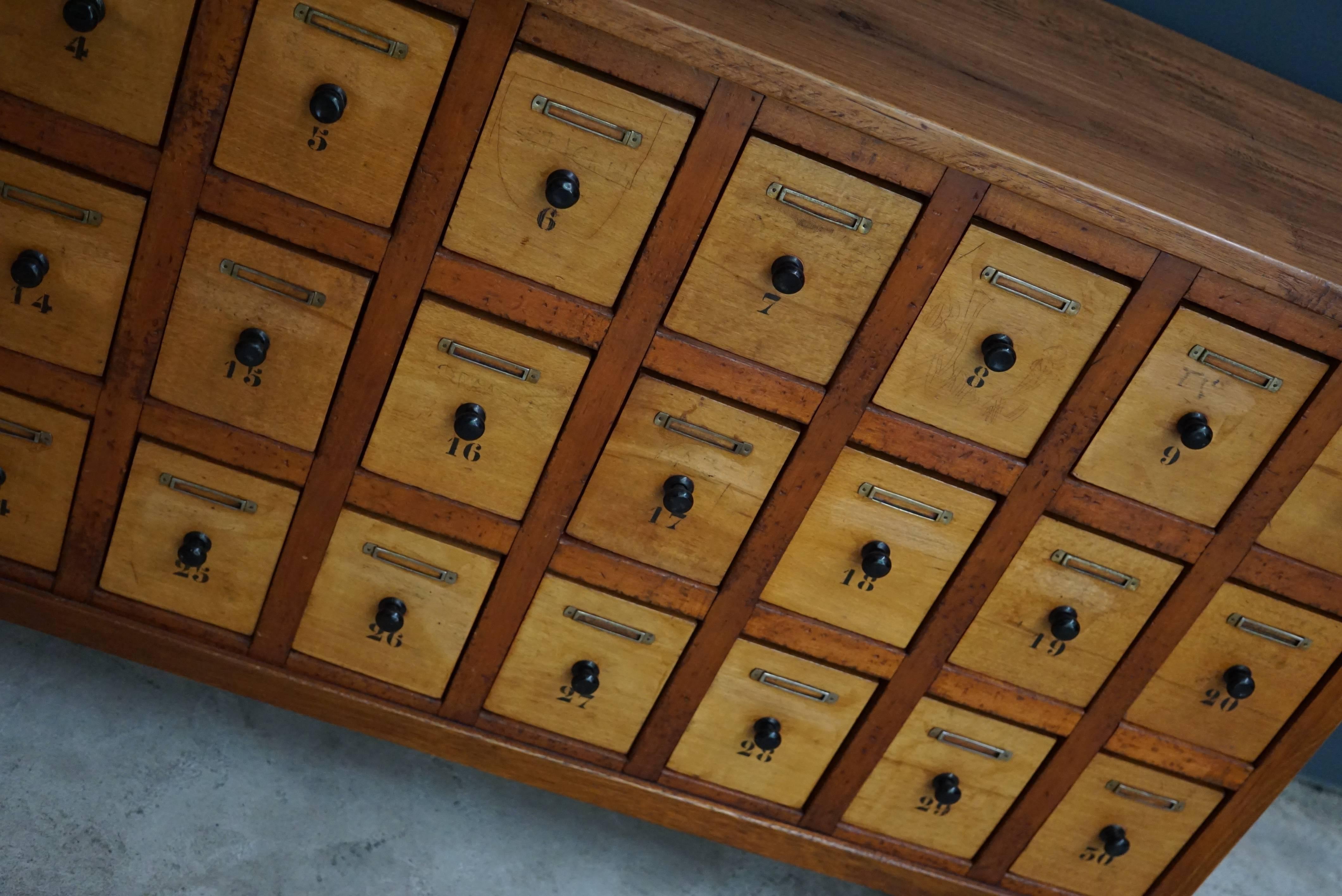 This apothecary cabinet of drawers was designed, circa 1930s in the Netherlands. The piece is made from oak and beech and features many drawers signed with numbers.