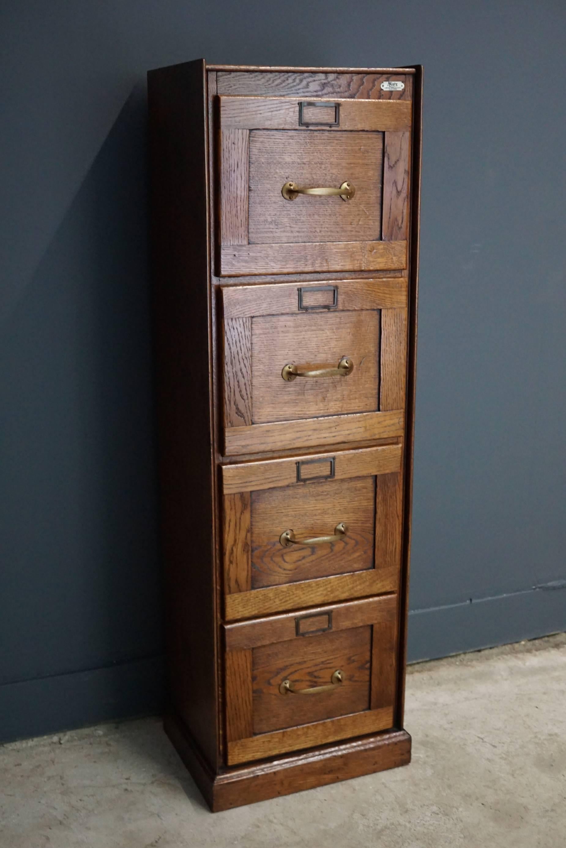 This filing cabinet was designed, circa 1930s in England. The cabinet is made from oak and features four drawers with brass handles.