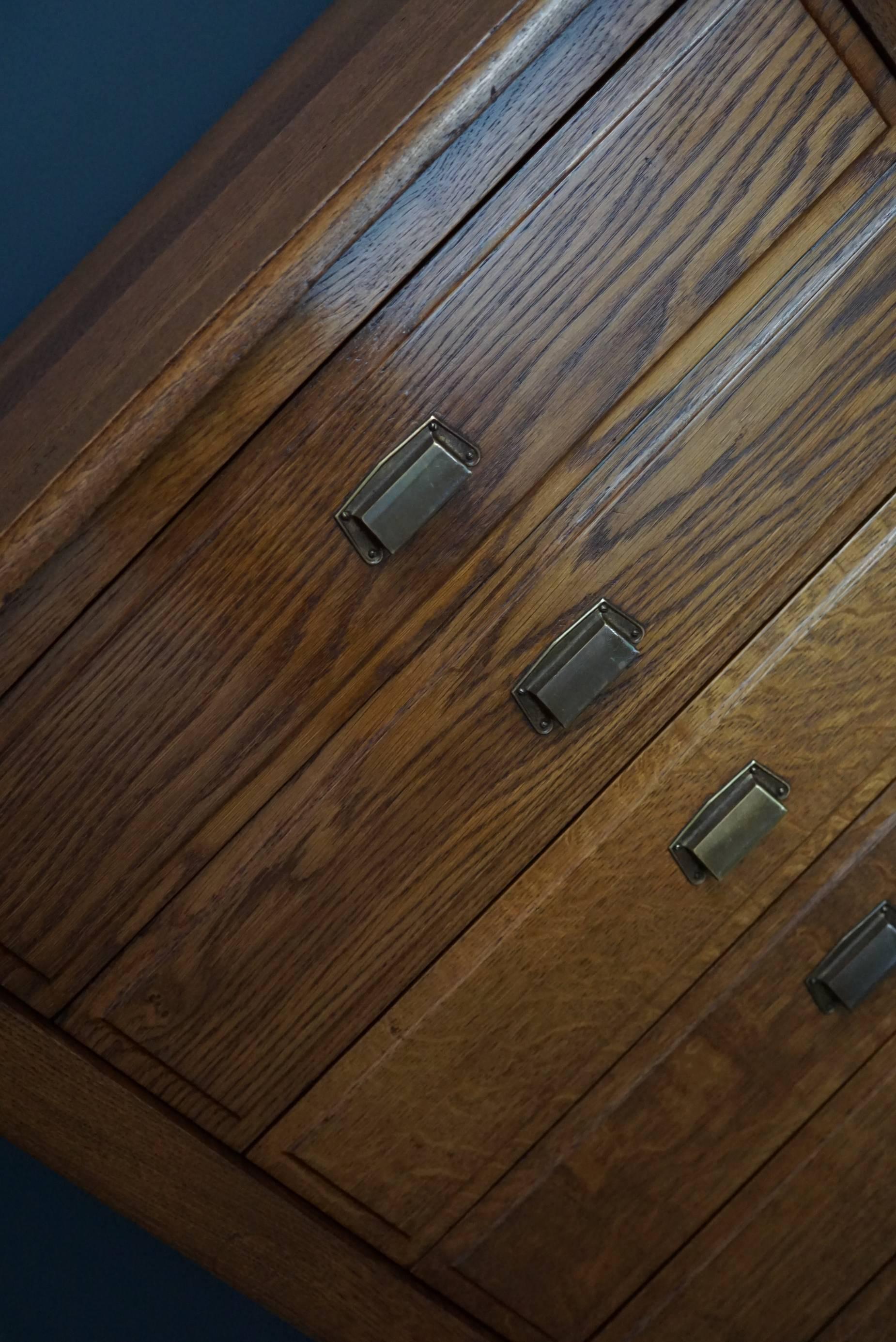 This filing cabinet was designed, circa 1930s in France. The cabinet is made from oak and features seven drawers with metal handles.